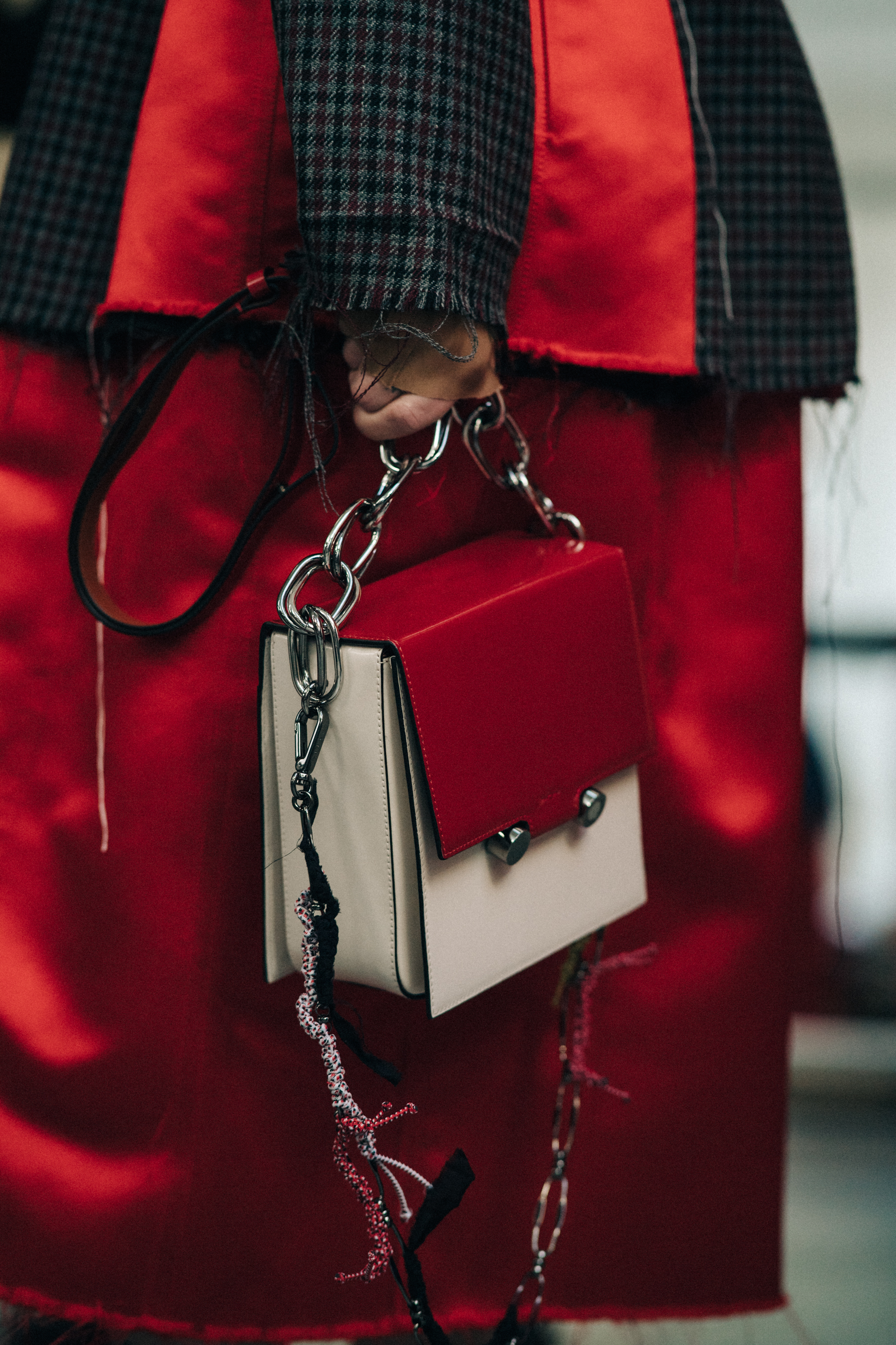 Crop of model in red holding red bag