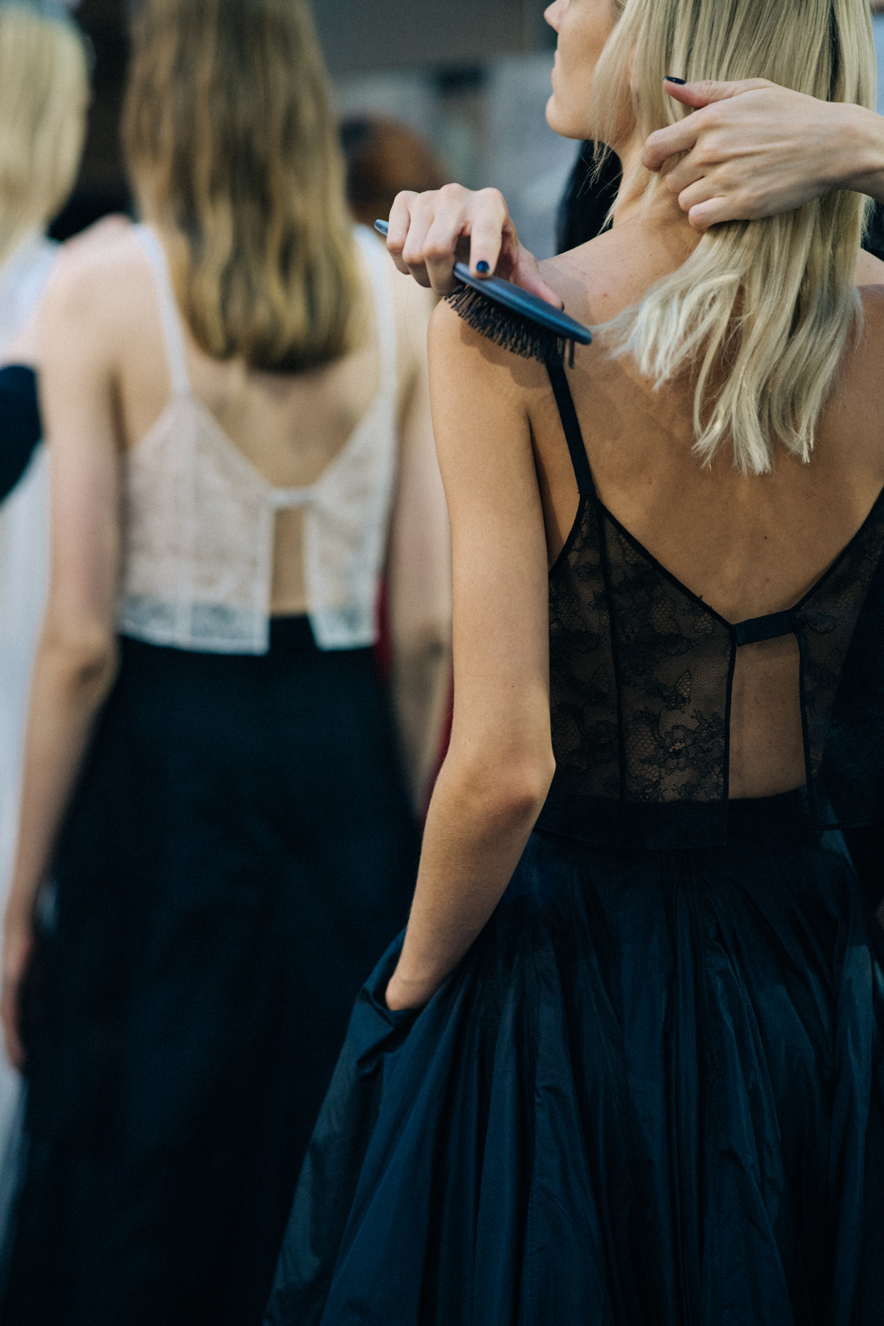Model wearing black outfit before a show
