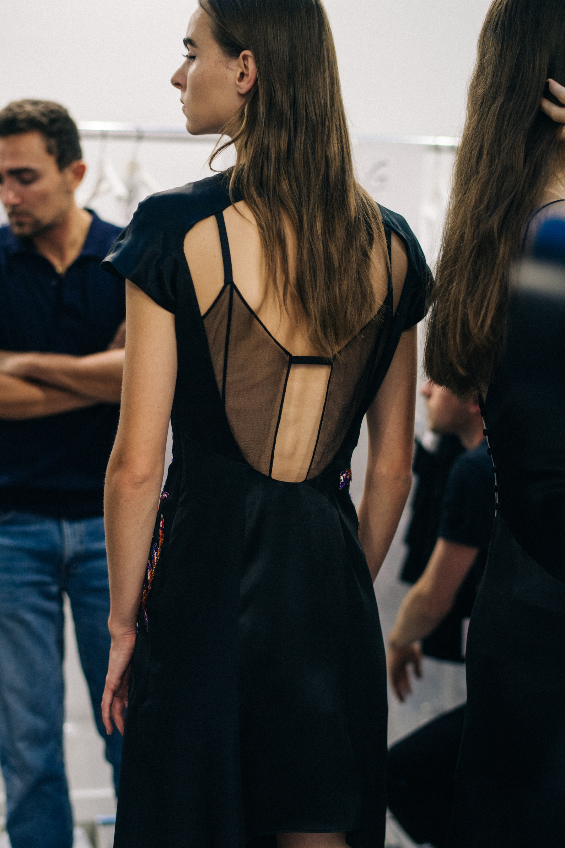 Model wearing black outfit before a show