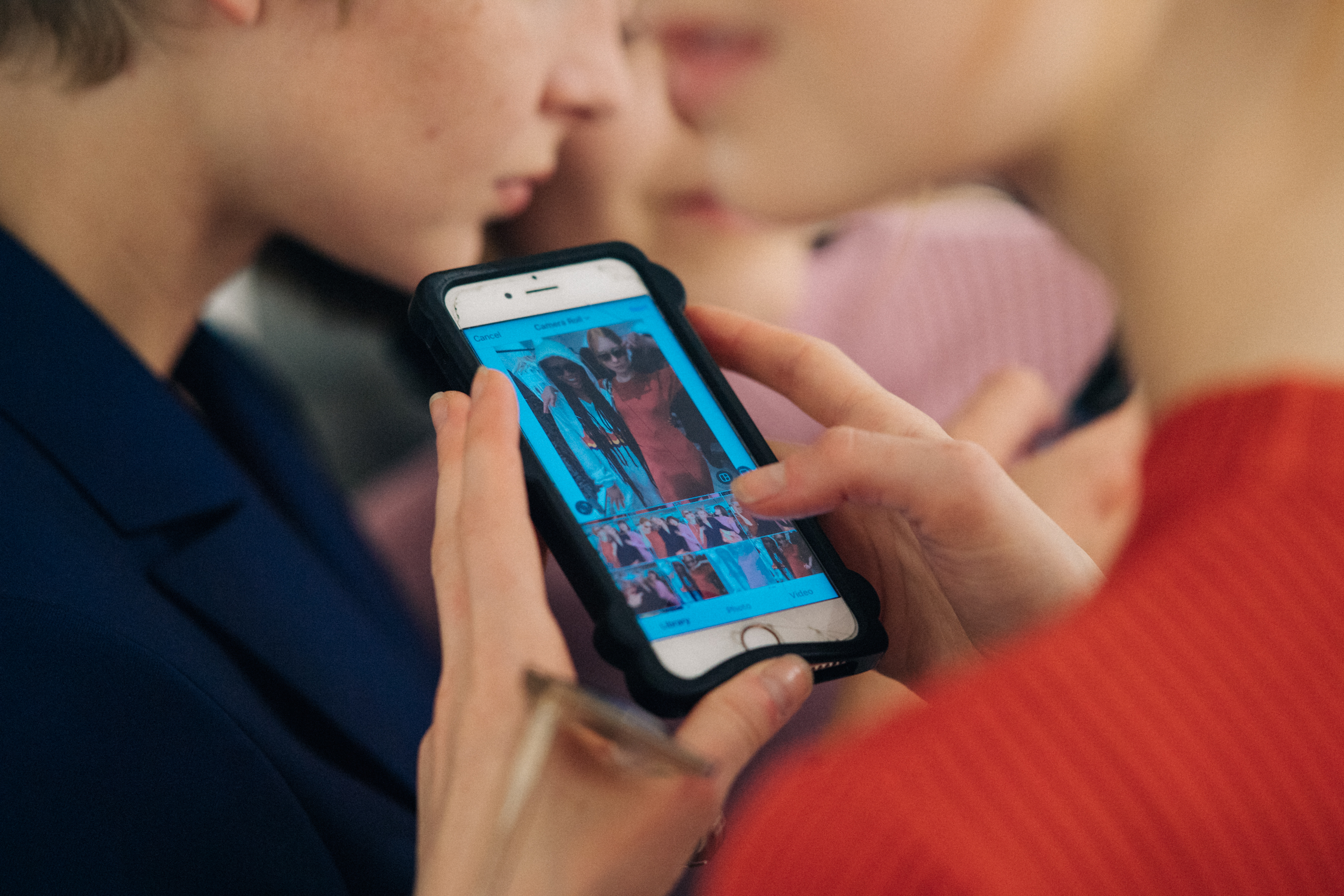 Woman swapping through photos on iPhone
