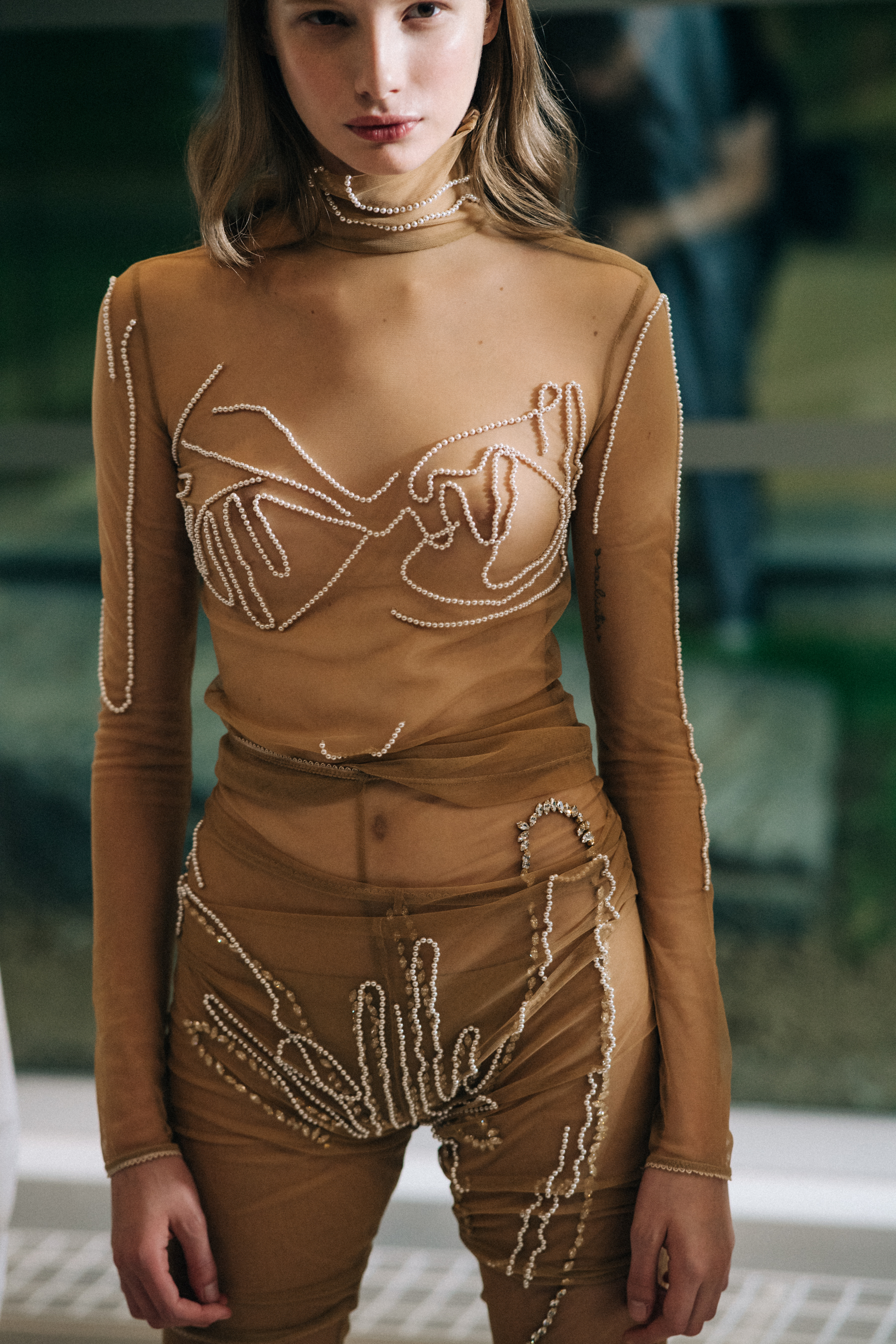Model wearing transparent beaded jumpsuit