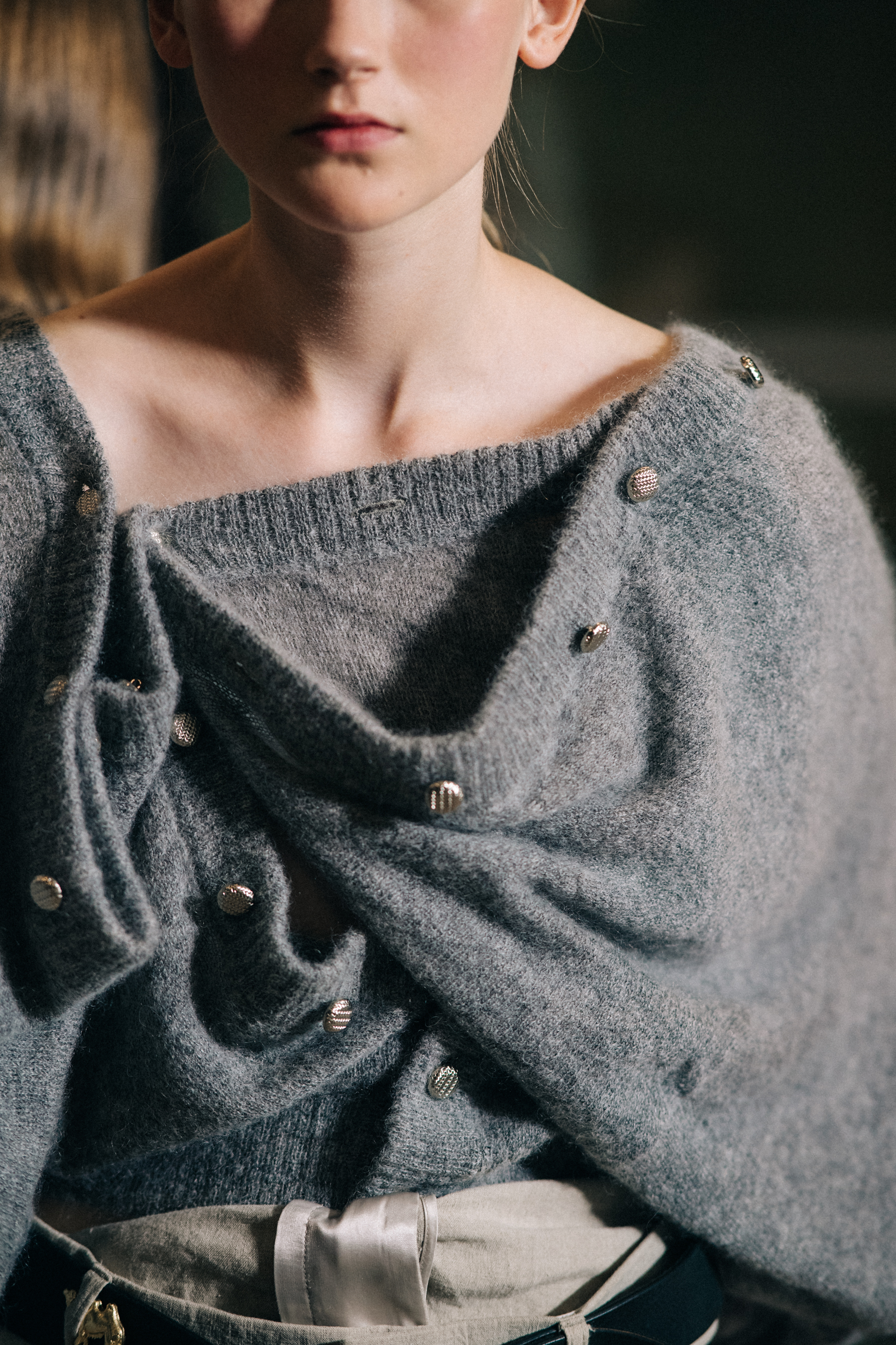 Model wearing gray deconstructed sweater