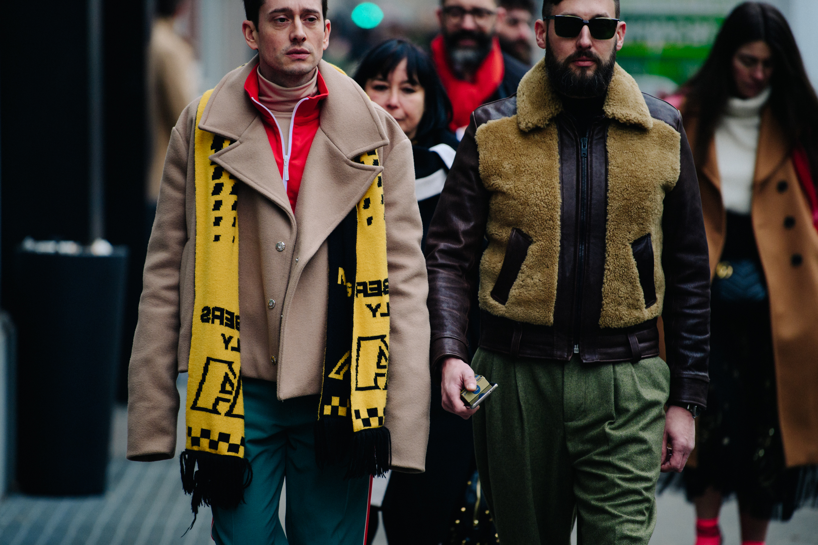 Two men wearing brown coats