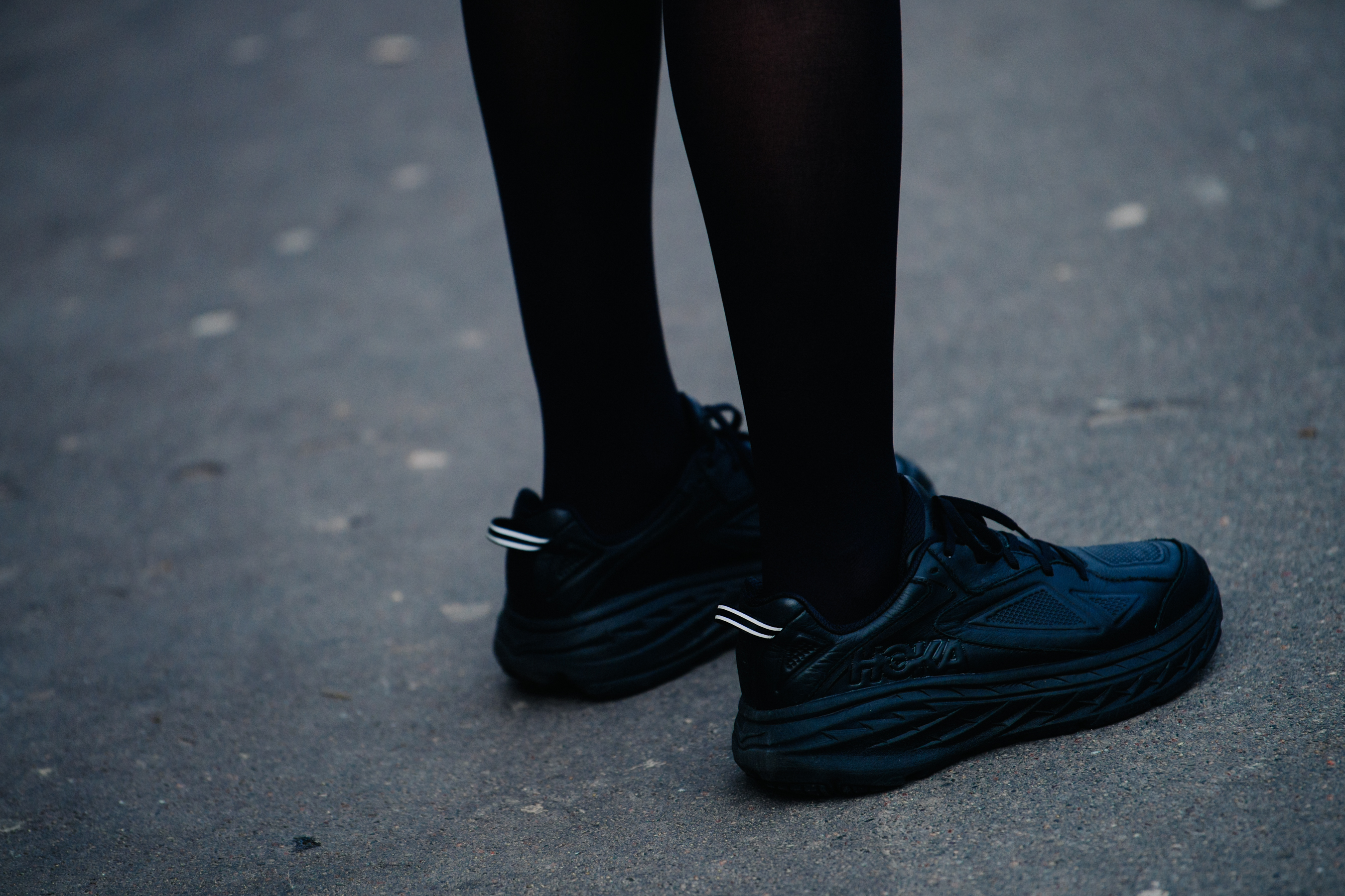 Woman wearing black Hoka sneakers