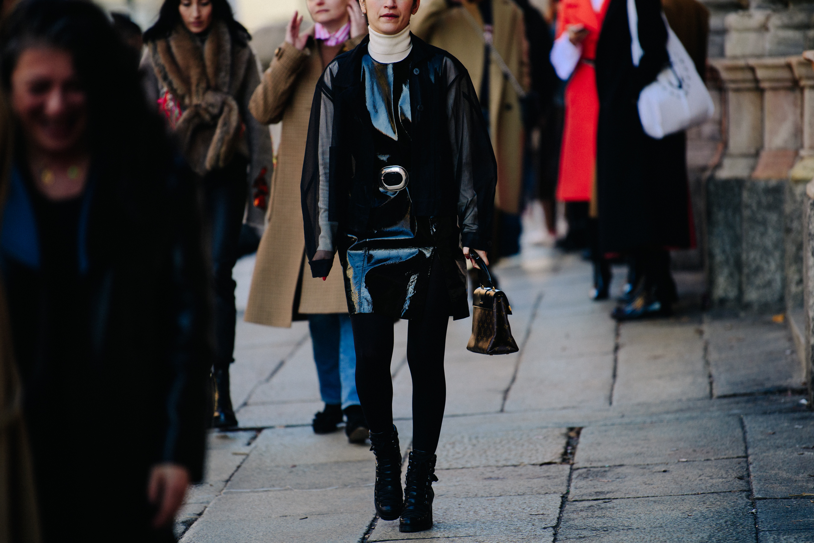 Woman wearing black patent coat