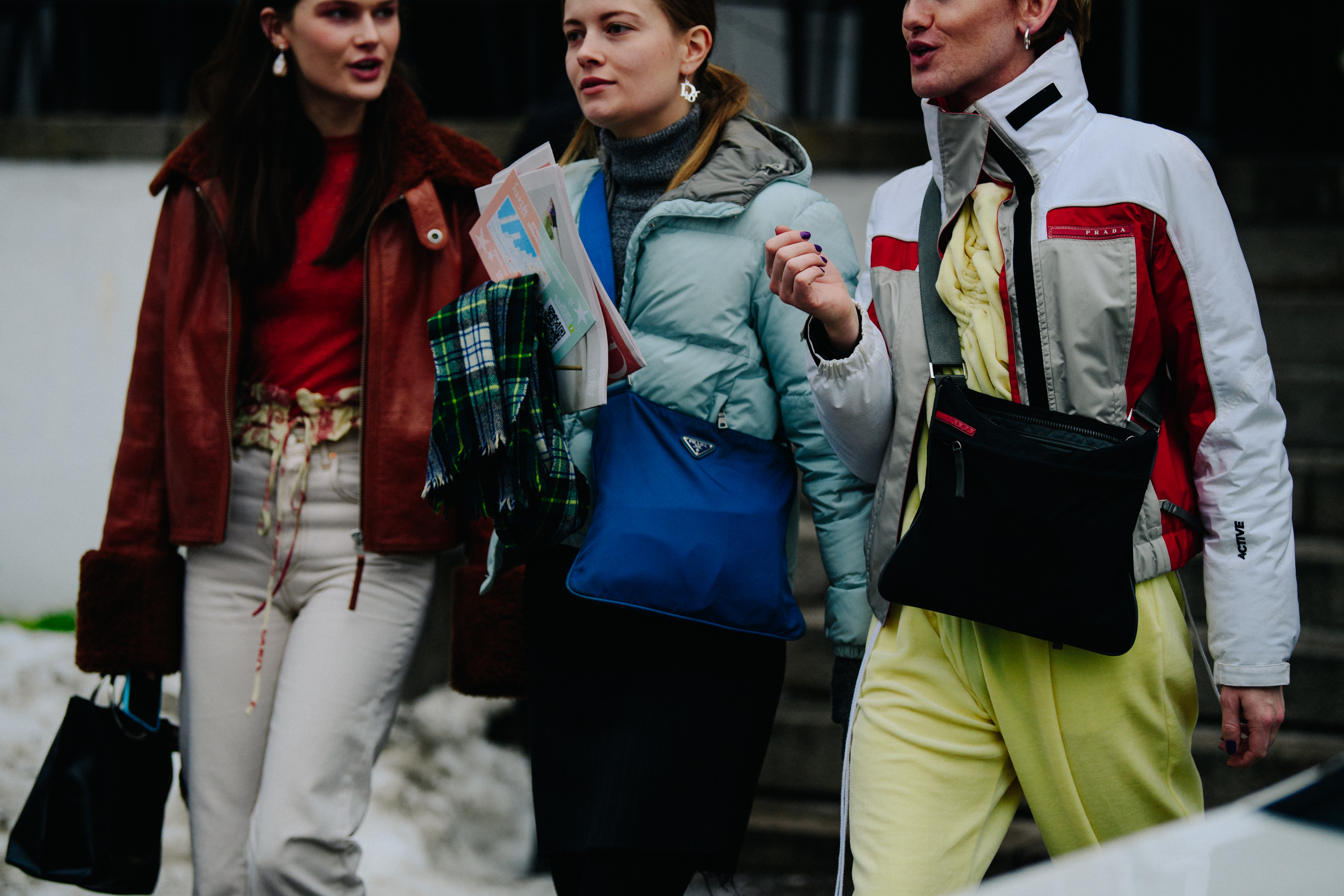 Three people wearing short winter coats