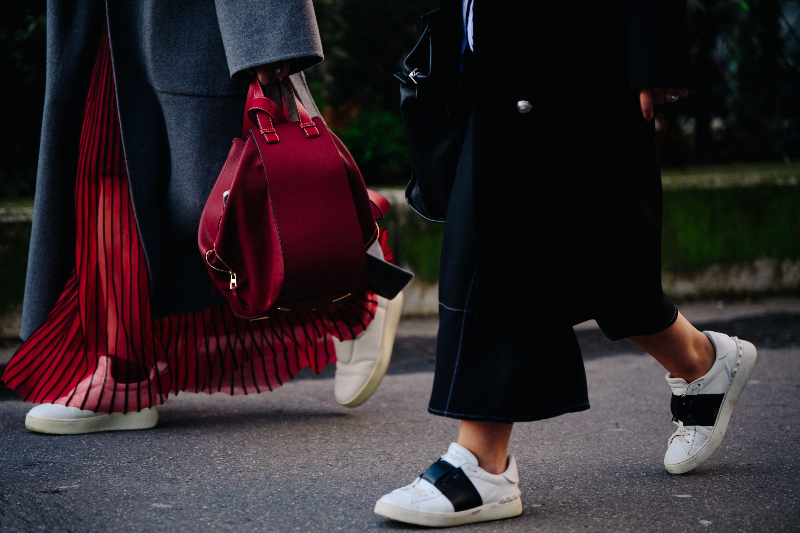 Two women wearing white sneakers