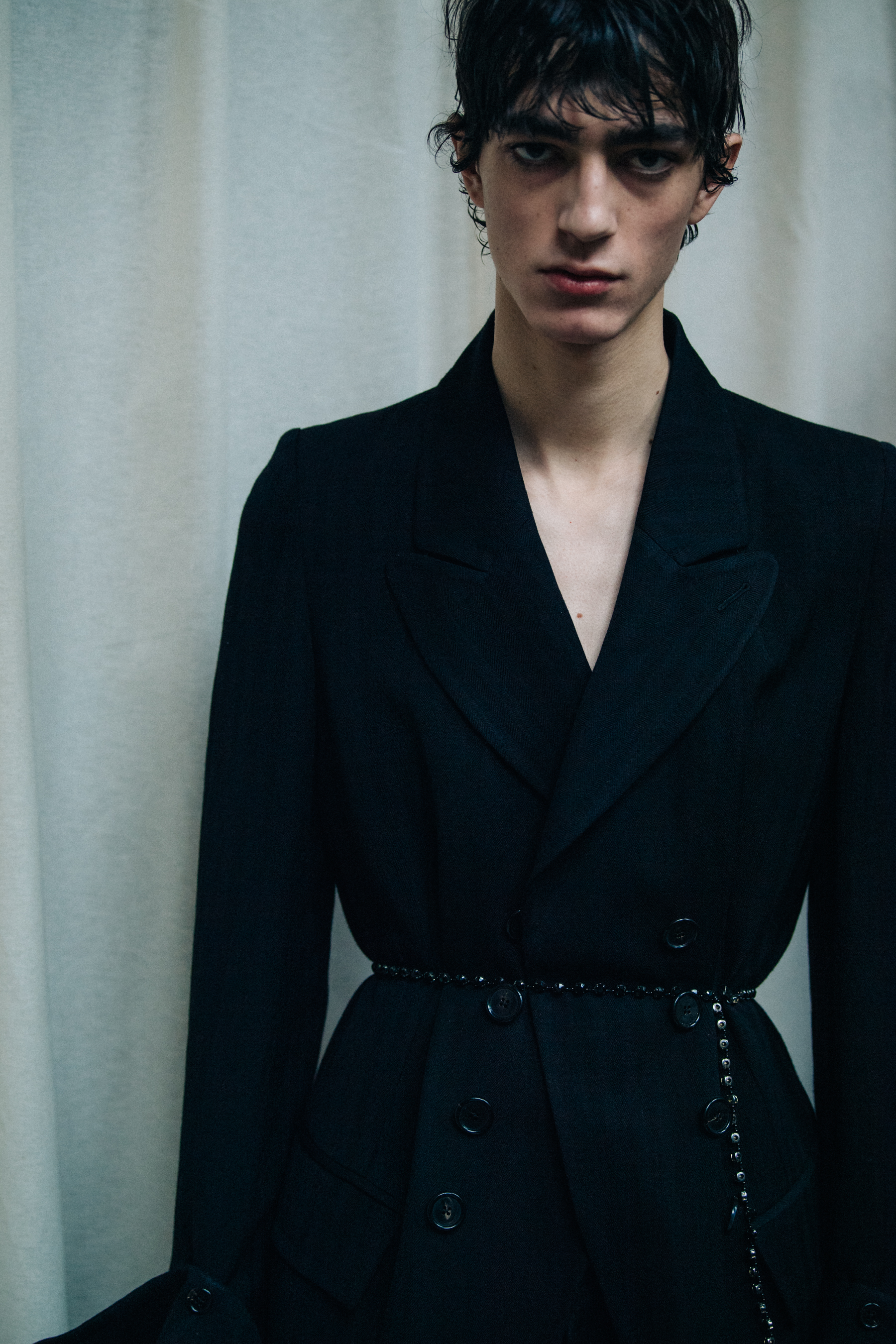 Model wearing black suit backstage