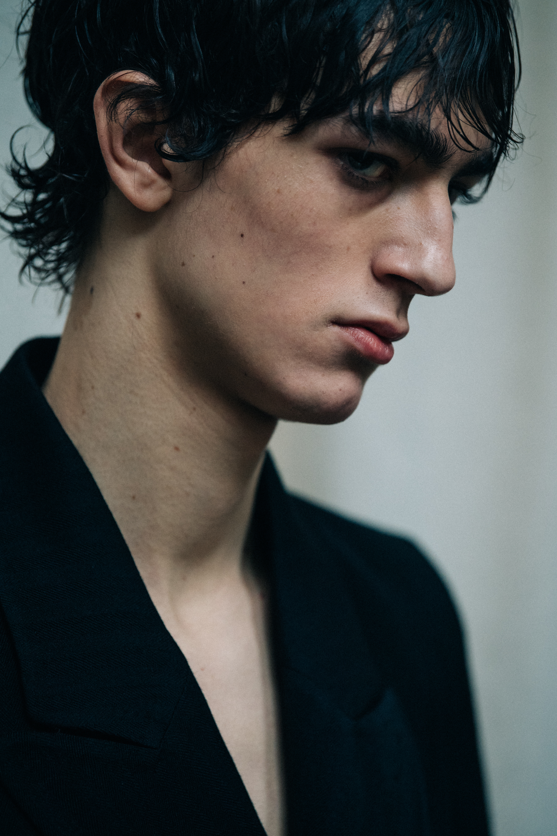 Model wearing black suit backstage