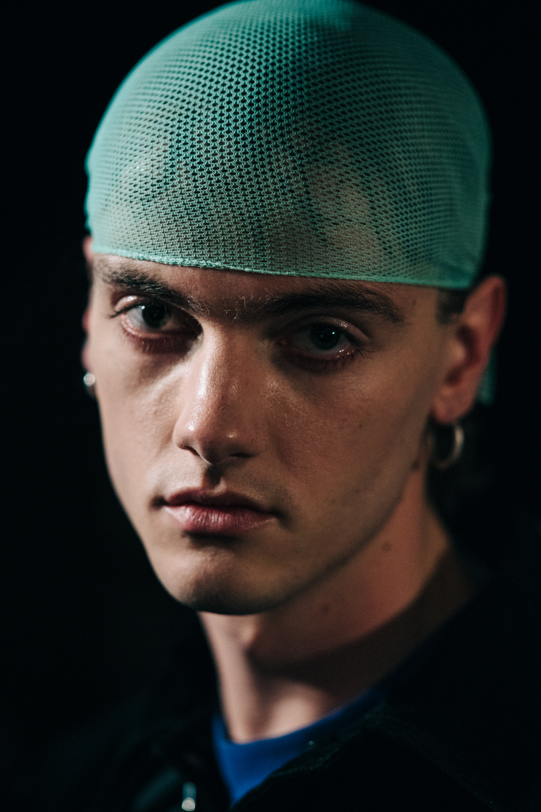 Portrait of model backstage with blue hair net