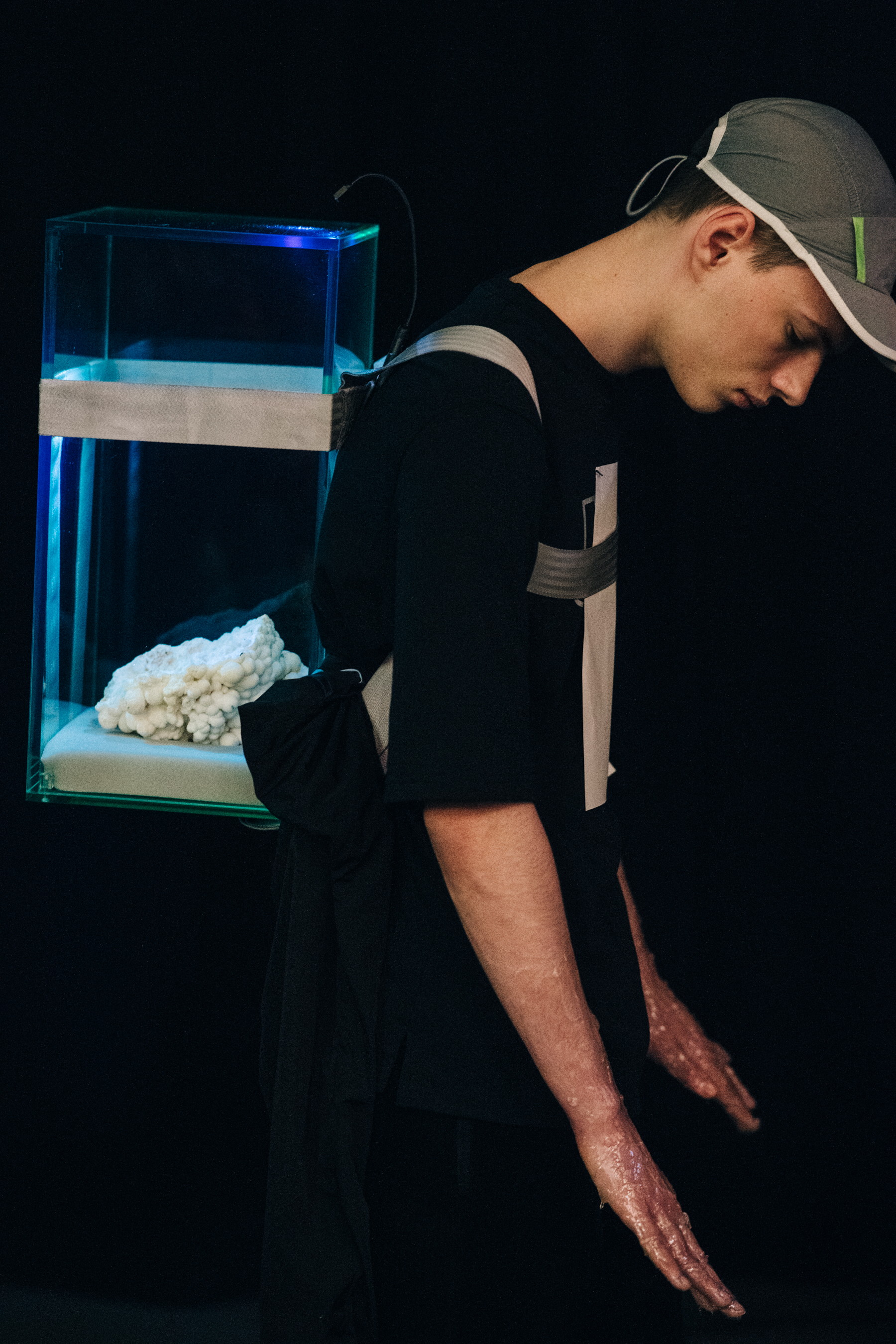 Model wearing plastic box as backpack