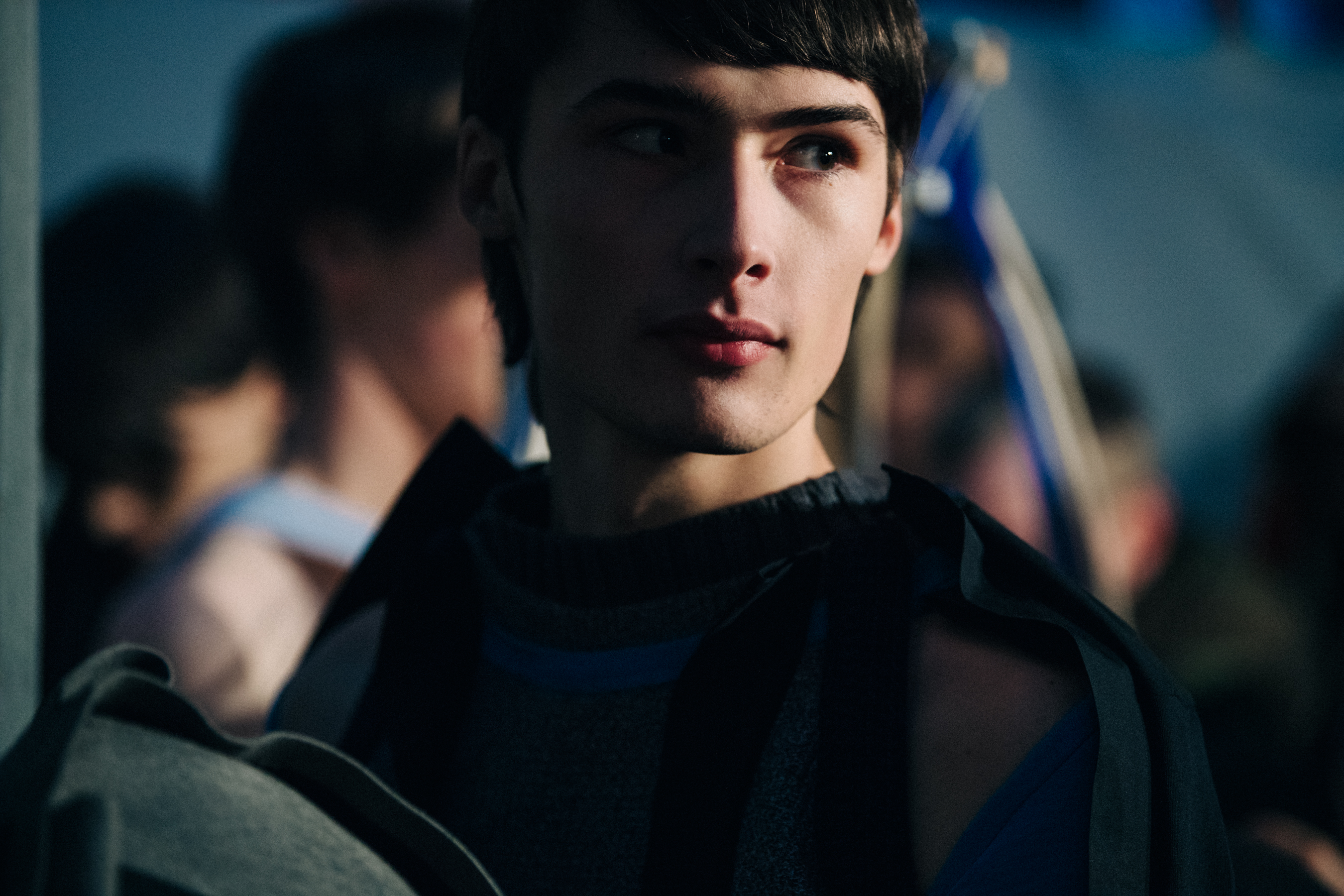Model wearing dark grey outfit backstage