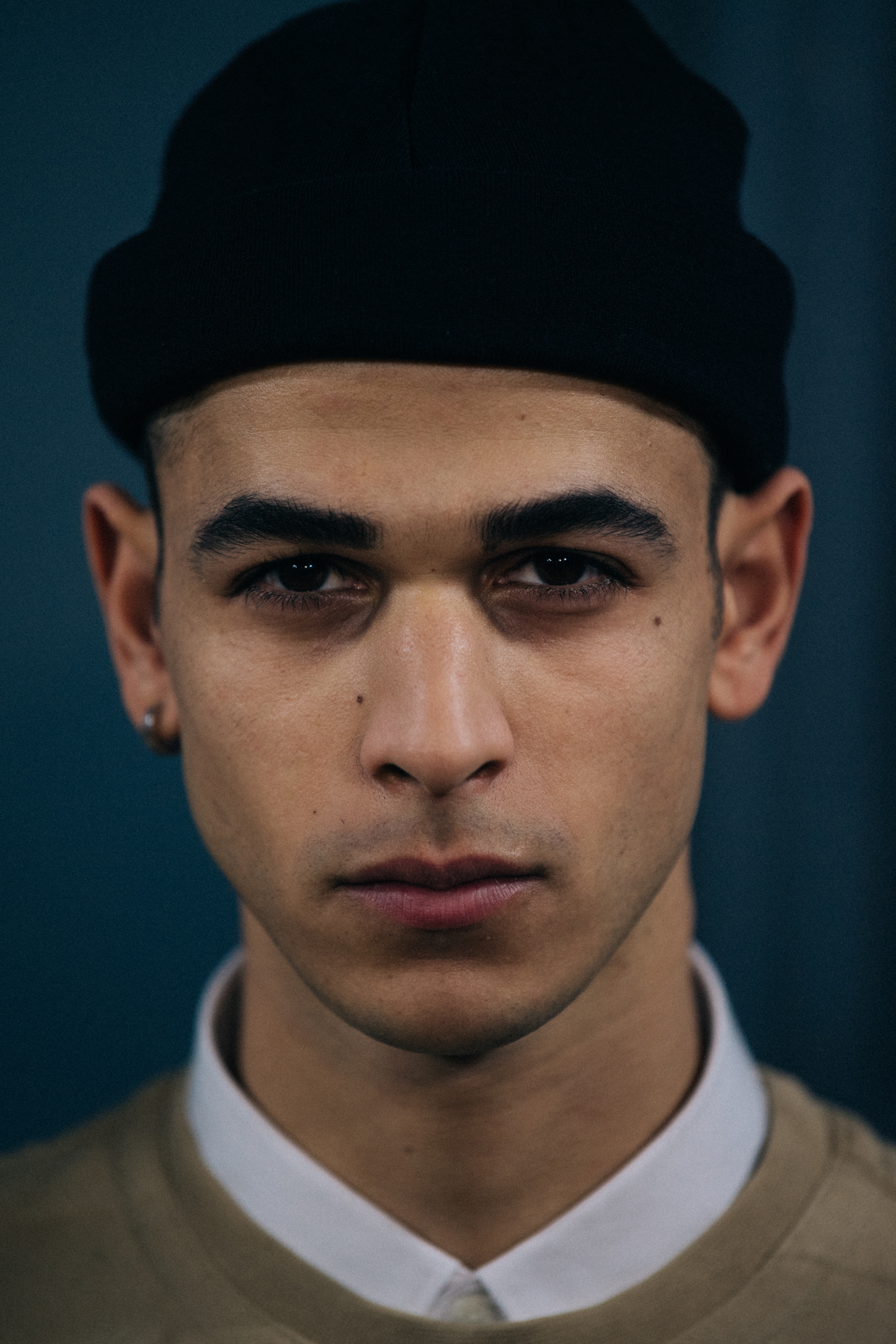 Portrait of model wearing black beanie backstage