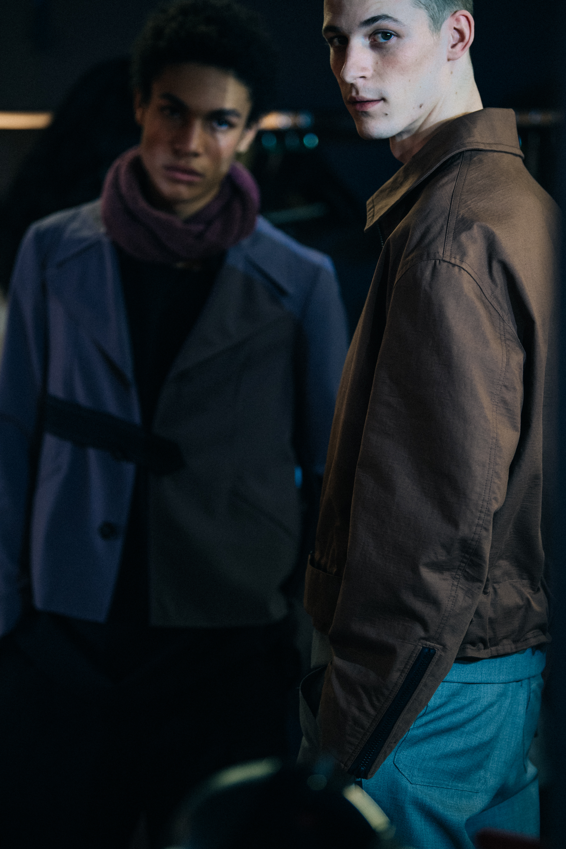 Models wearing button up jackets backstage