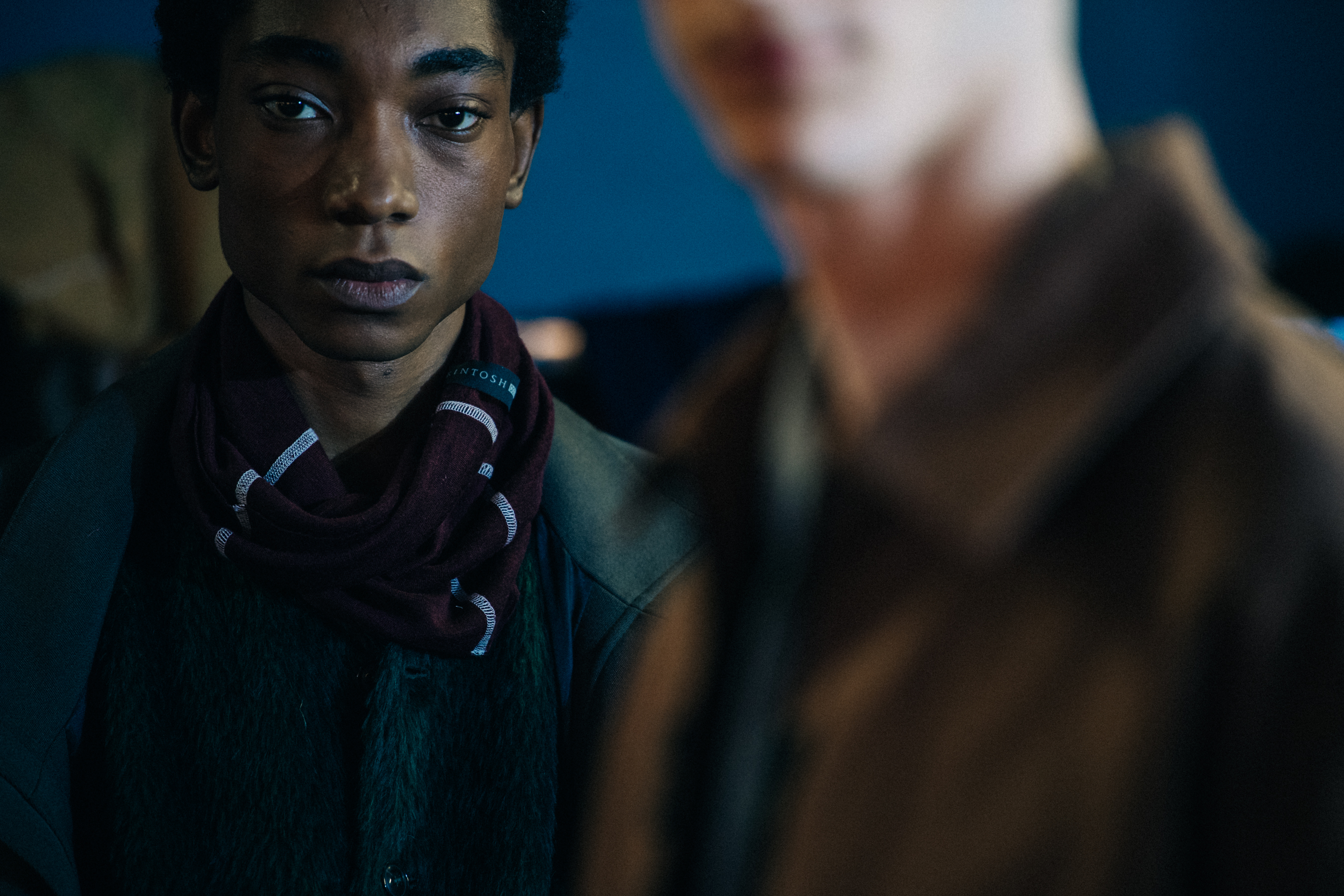 Models wearing button up jackets backstage
