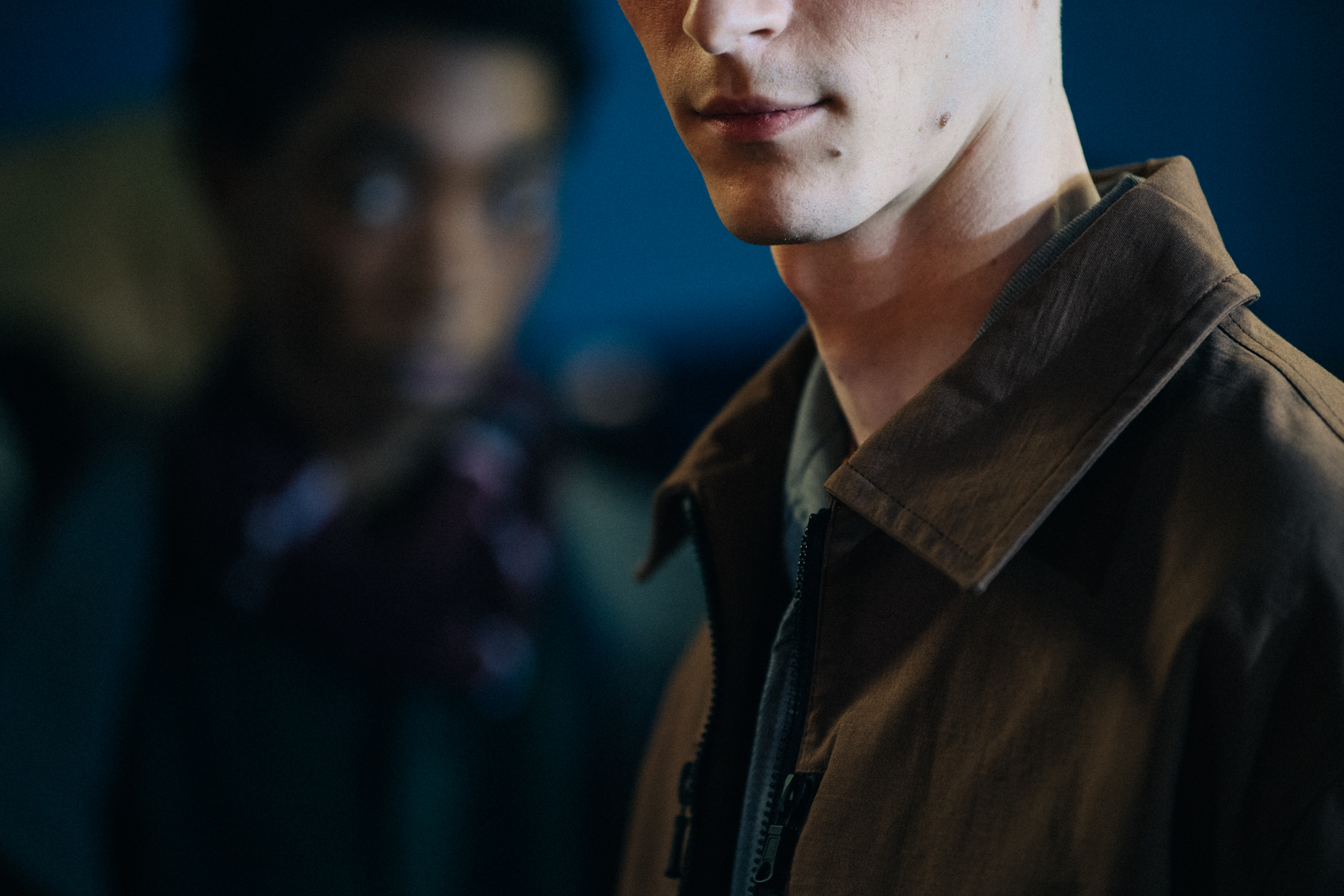 Models wearing button up jackets backstage