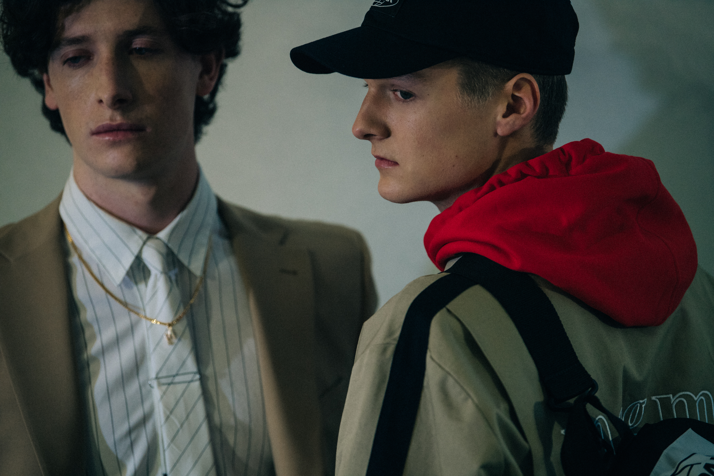 Models wearing camel jackets and red hoodie