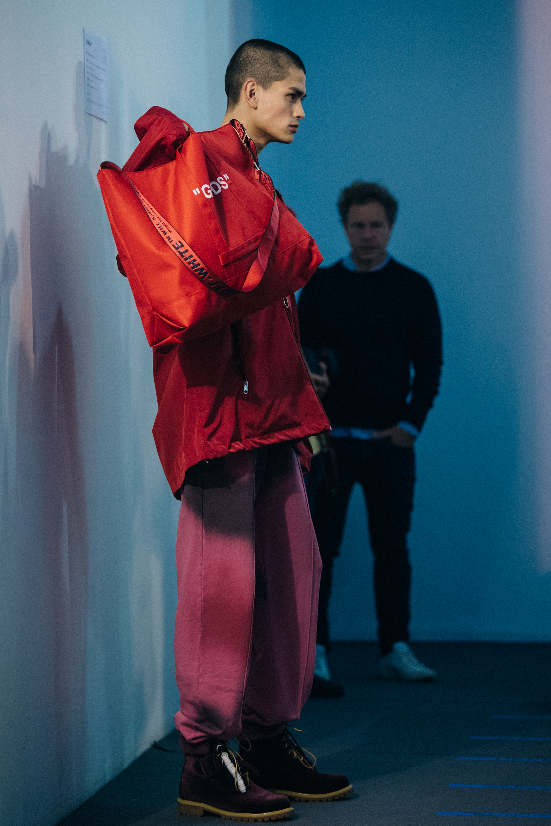 Model holding red bag backstage