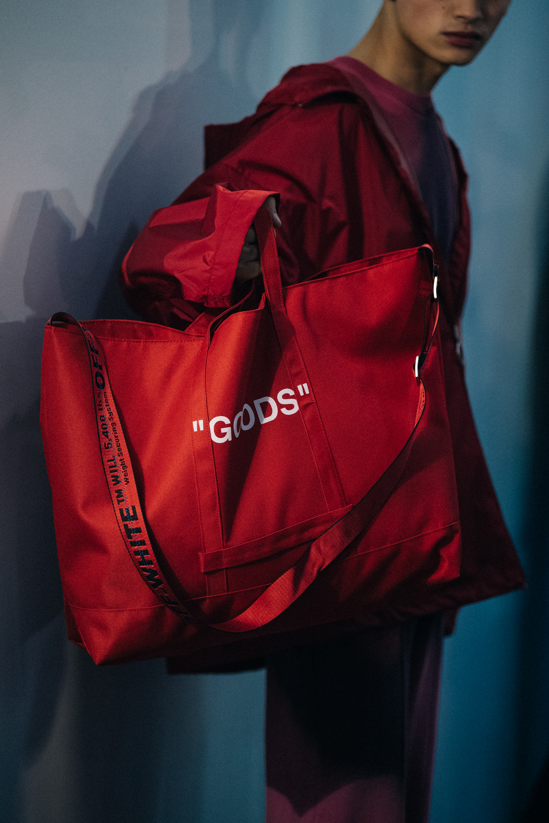 Model holding red bag backstage
