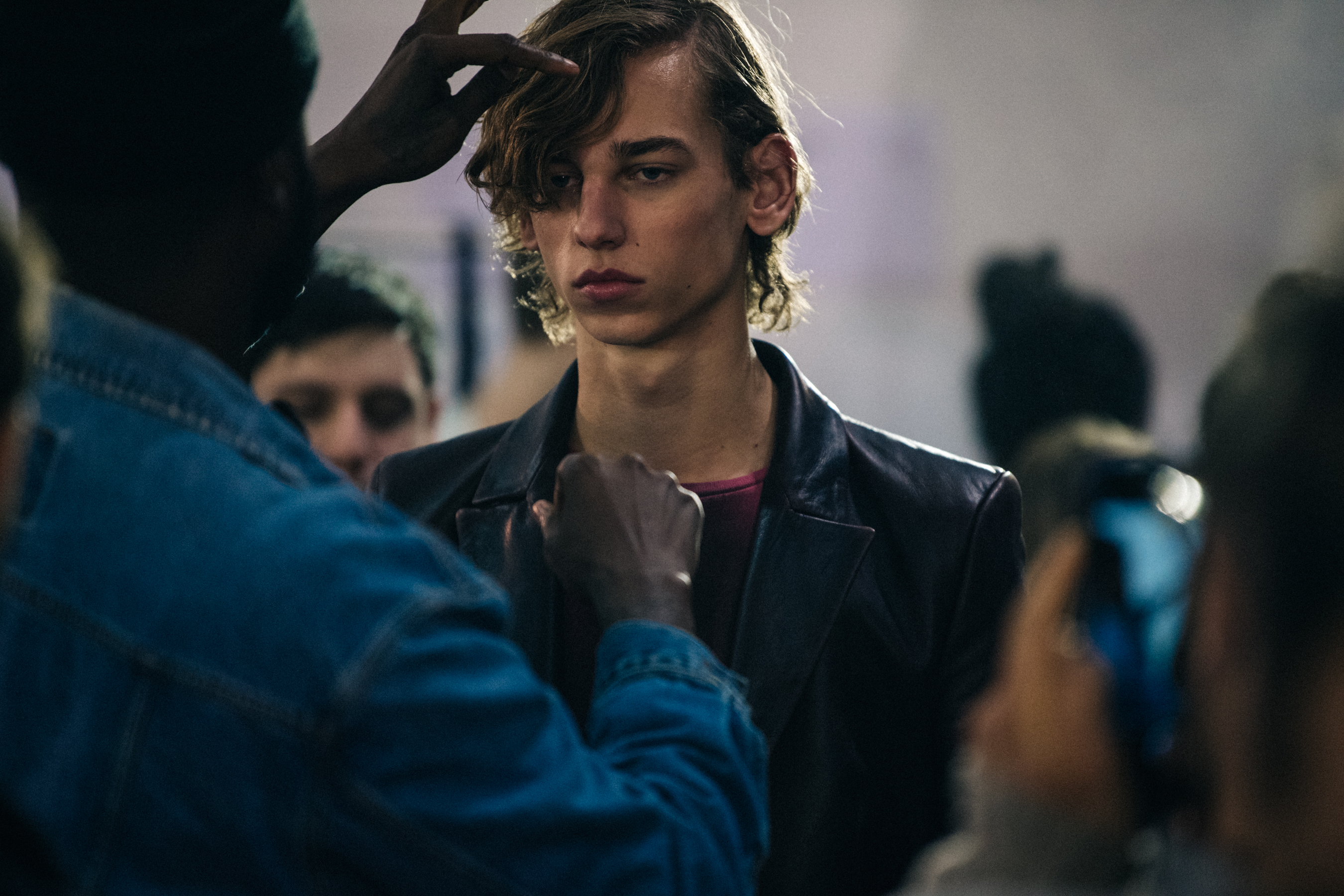 Model wearing leather coat backstage