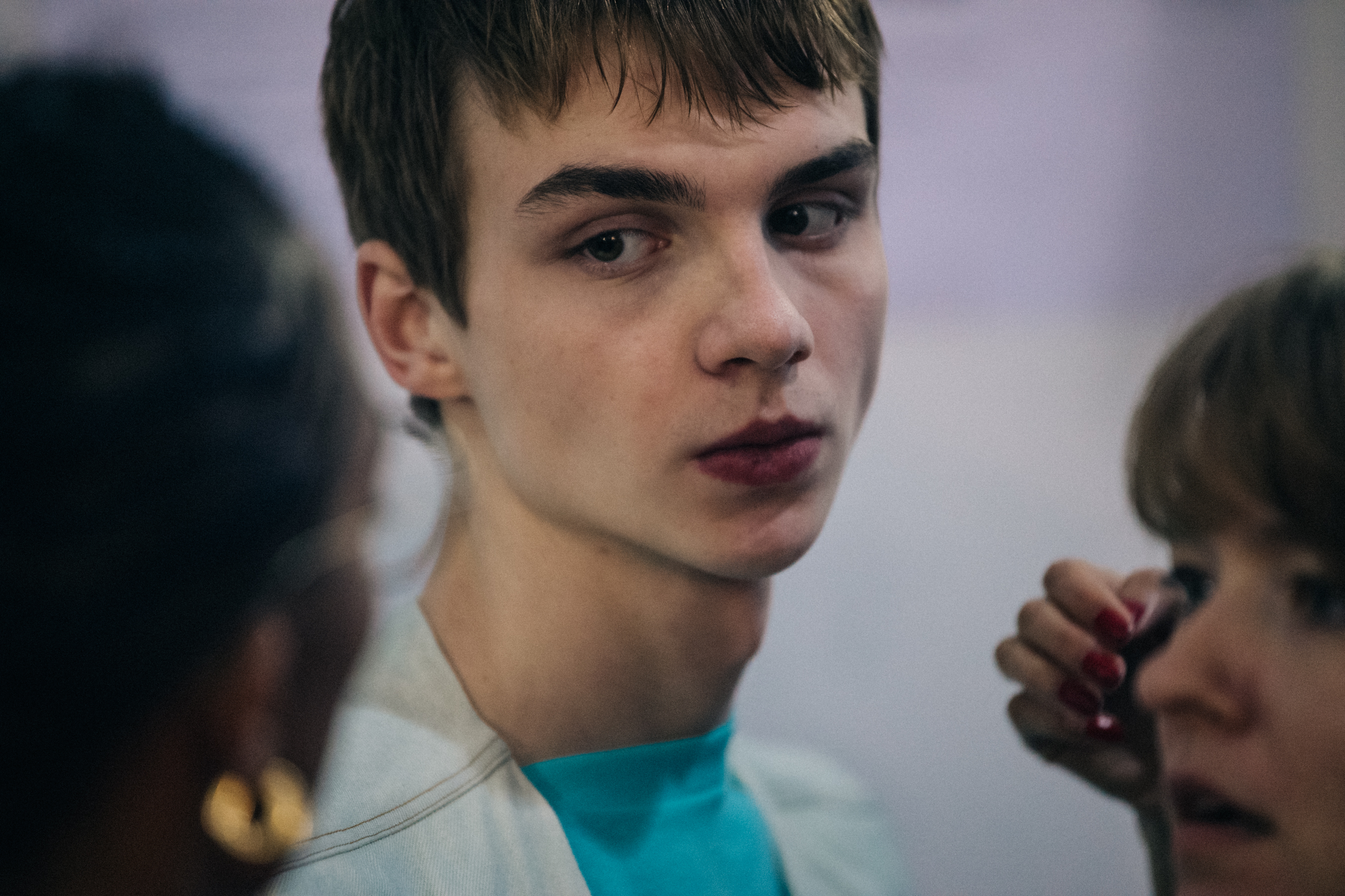 Model wearing blue shirt and white vest