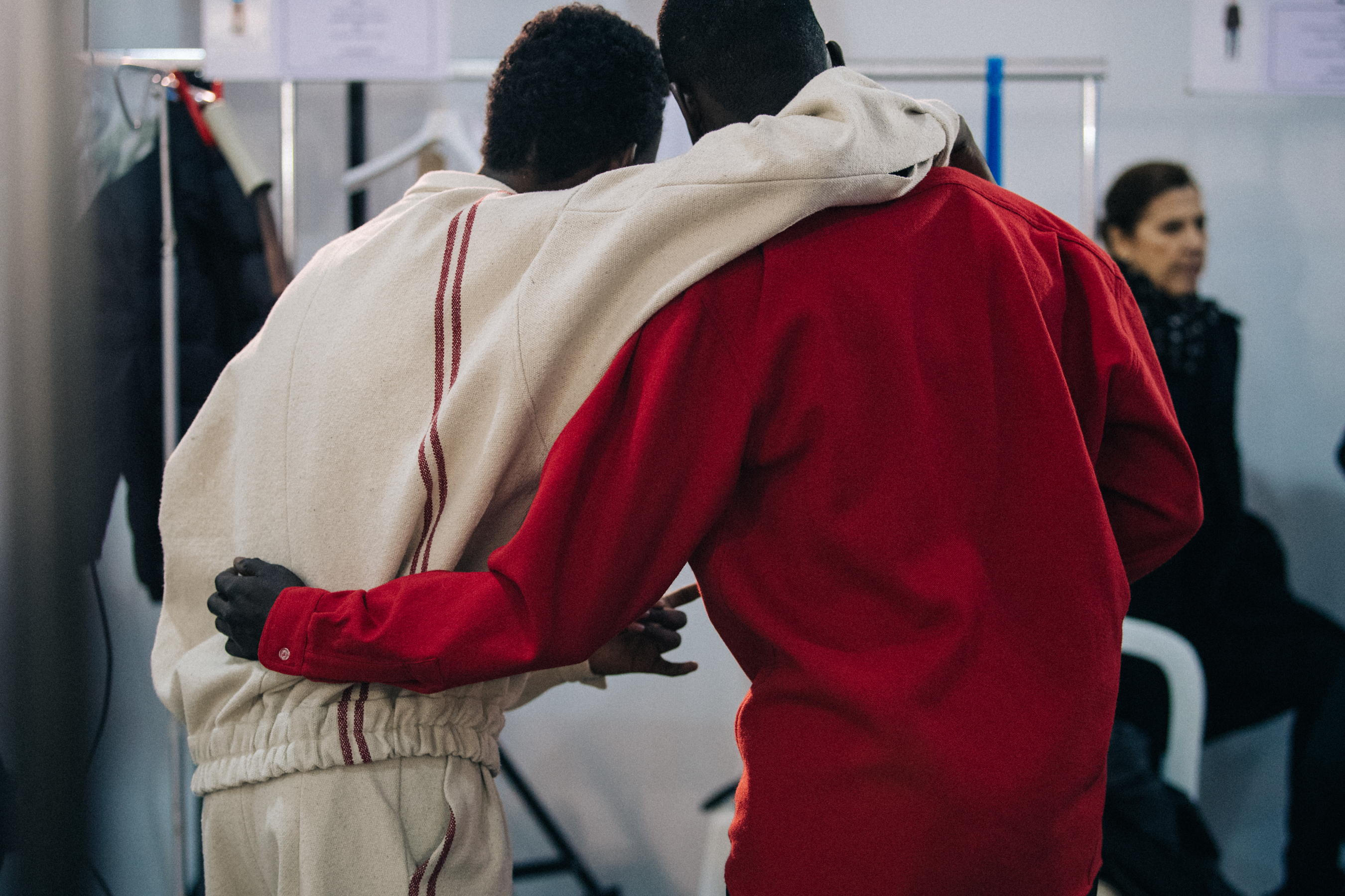 Two models hugging backstage