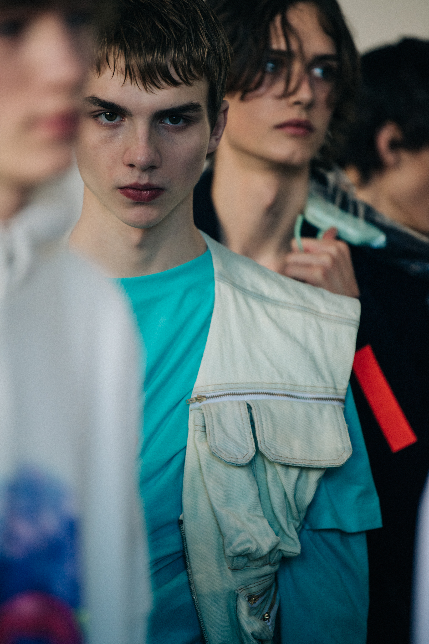 Model wearing blue shirt and white vest
