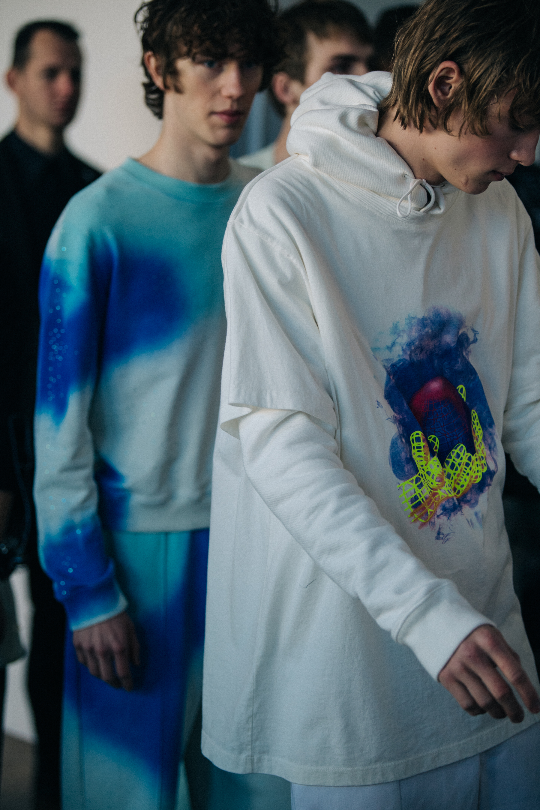 Model wearing white hoodie with graphic