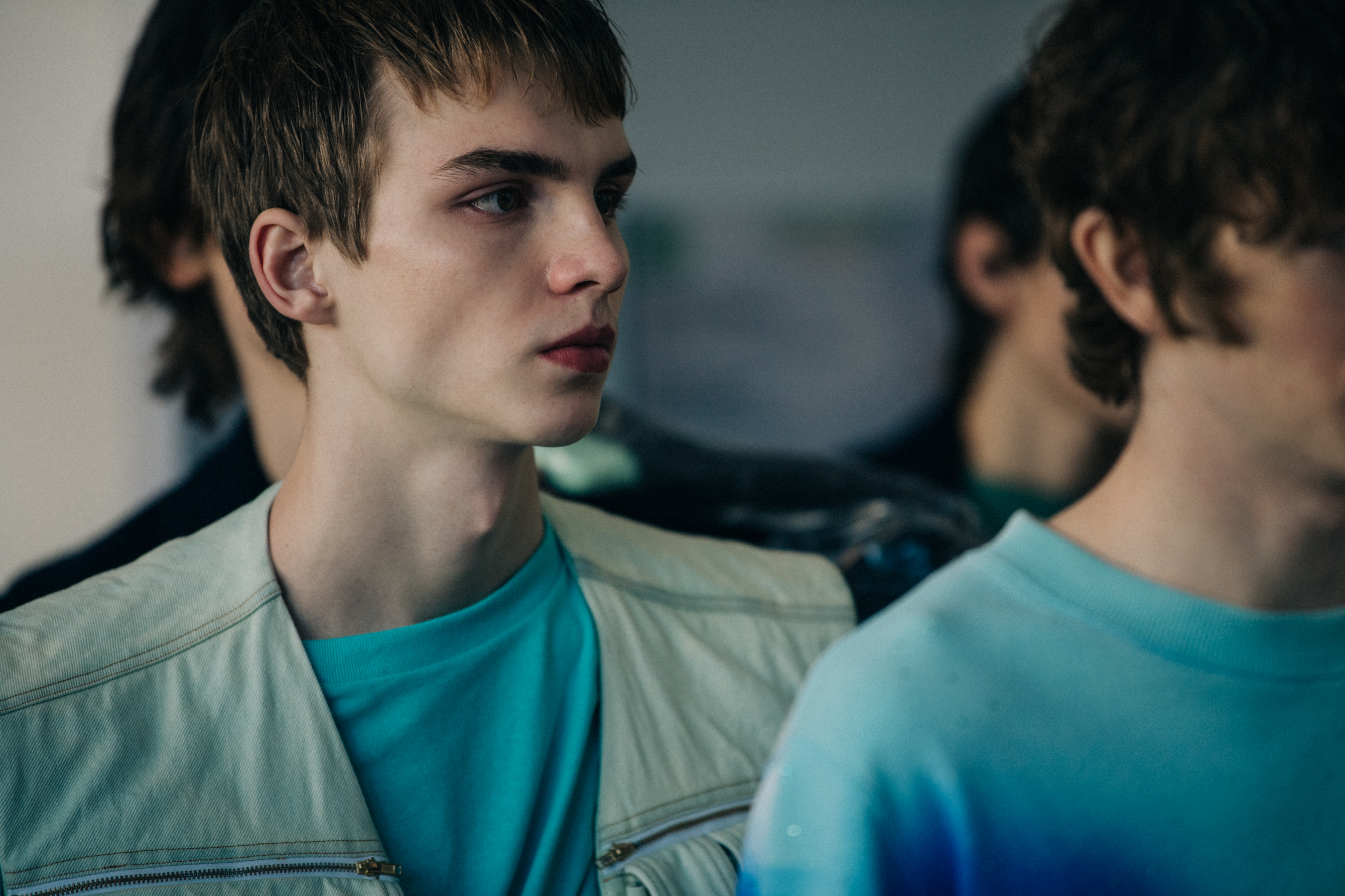 Model wearing blue shirt and white vest