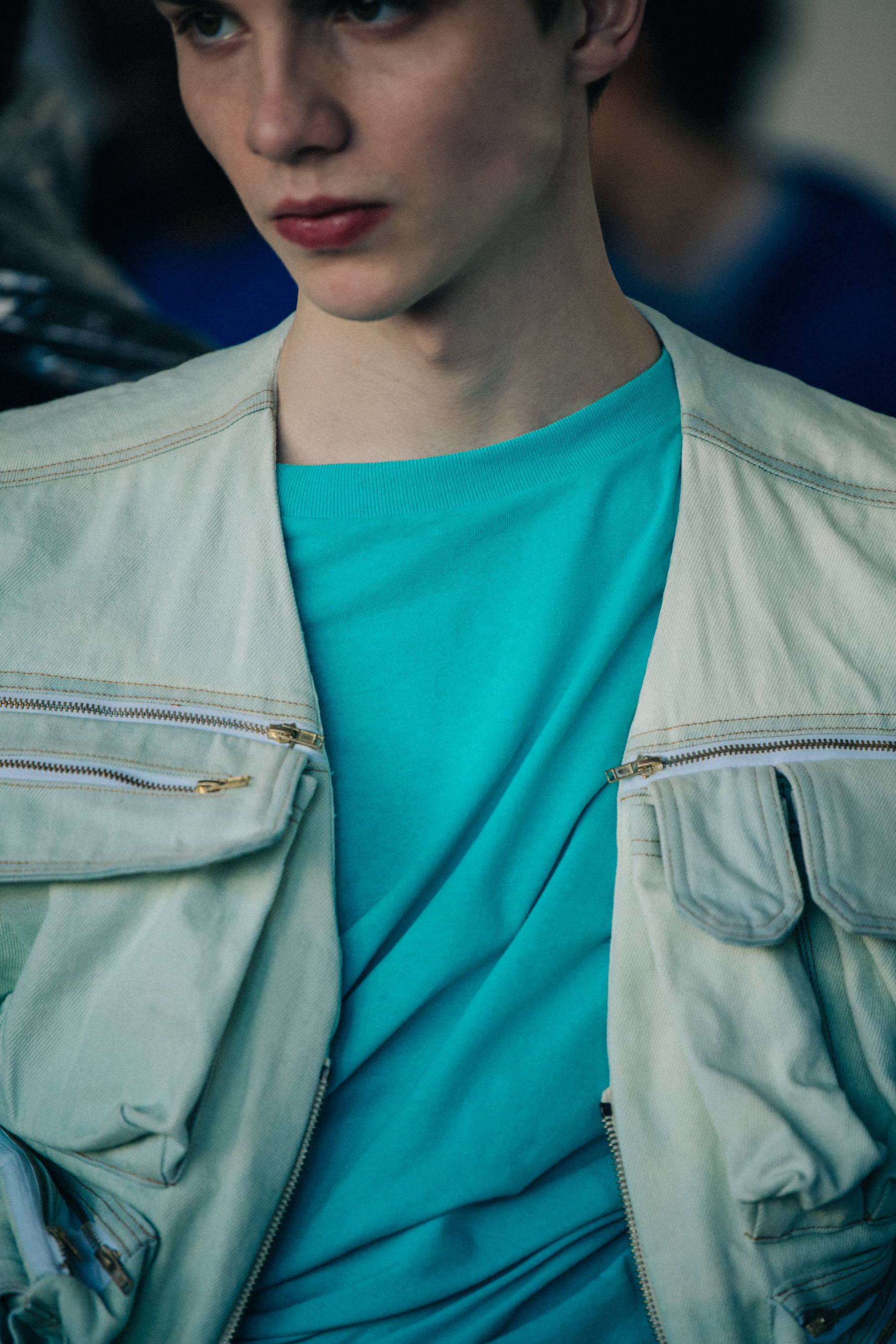 Model wearing blue shirt and white vest