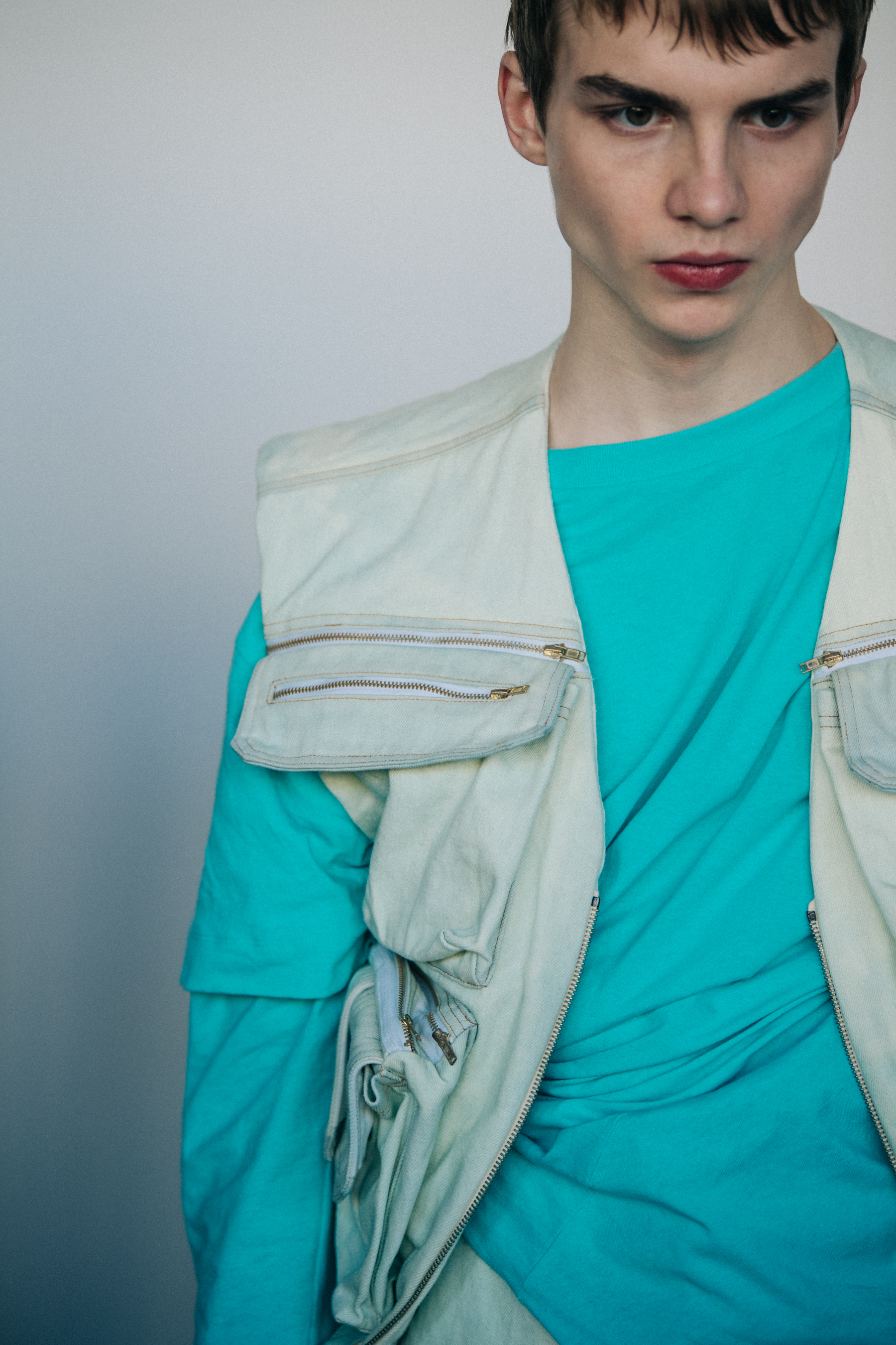 Model wearing blue shirt and white vest