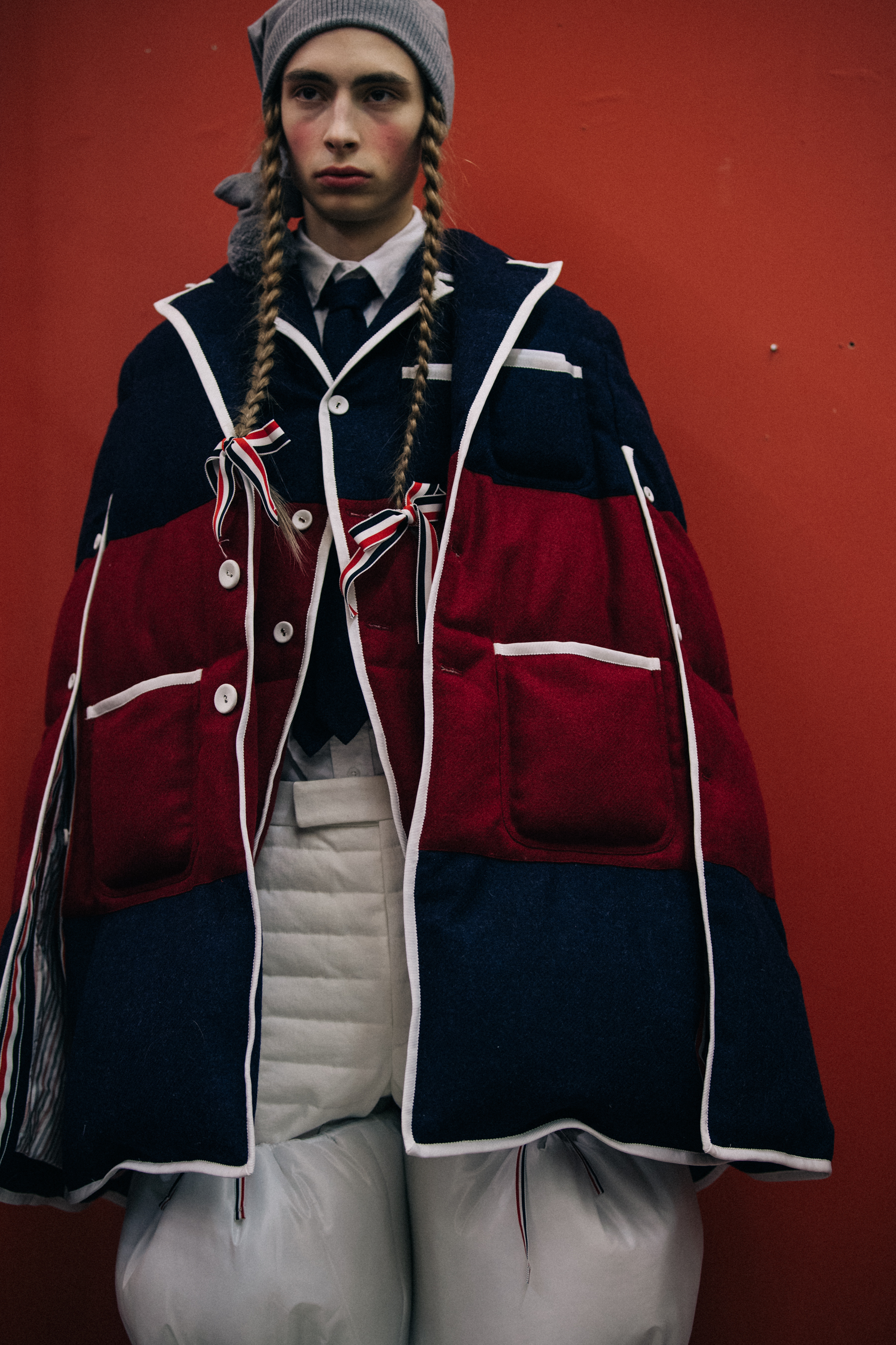 Model wearing red and blue Thom Browne cape