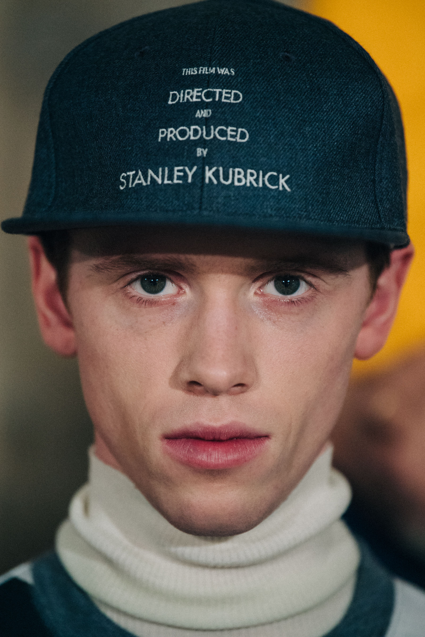 Portrait of model wearing green cap with text