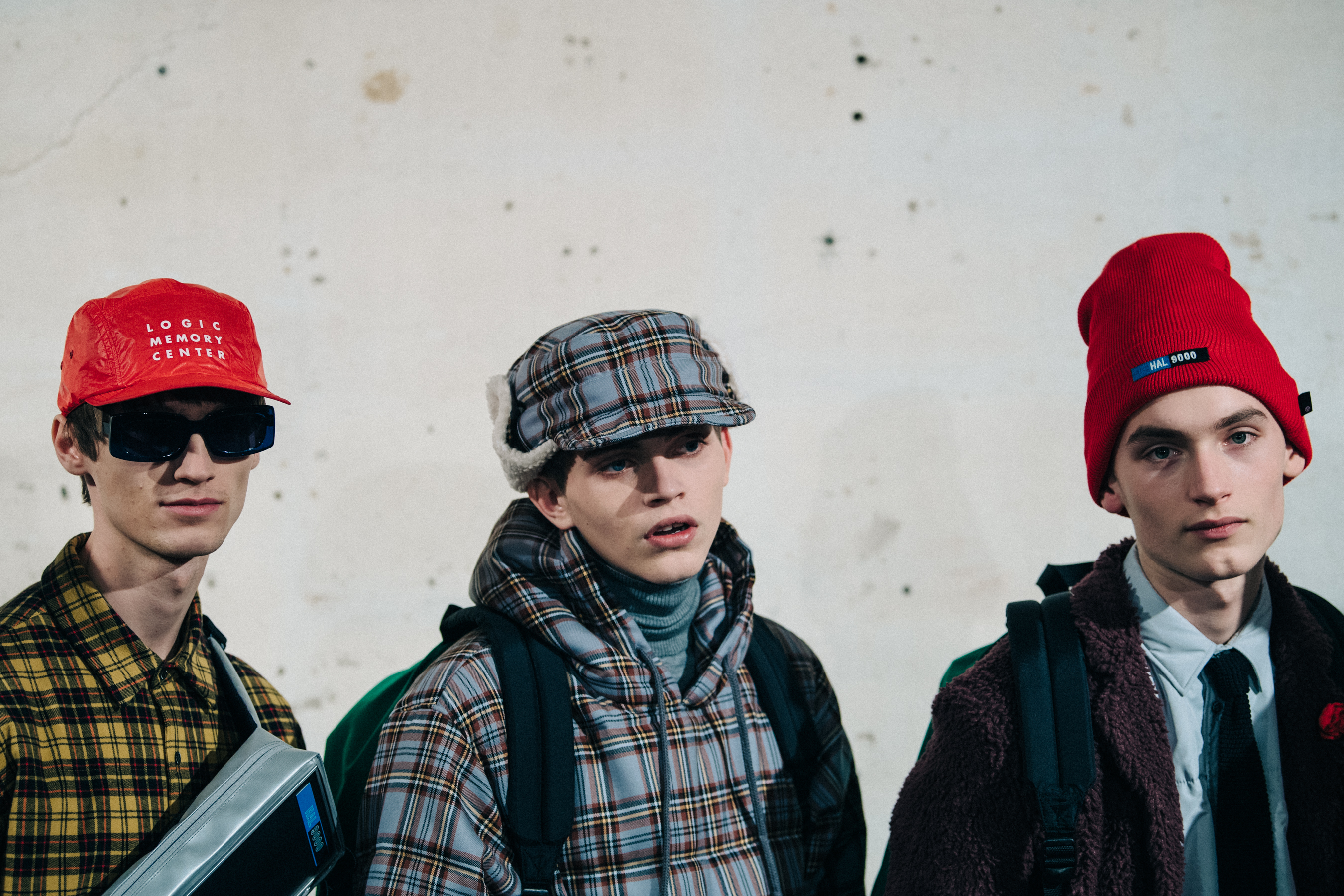 Three models wearing check outfits backstage