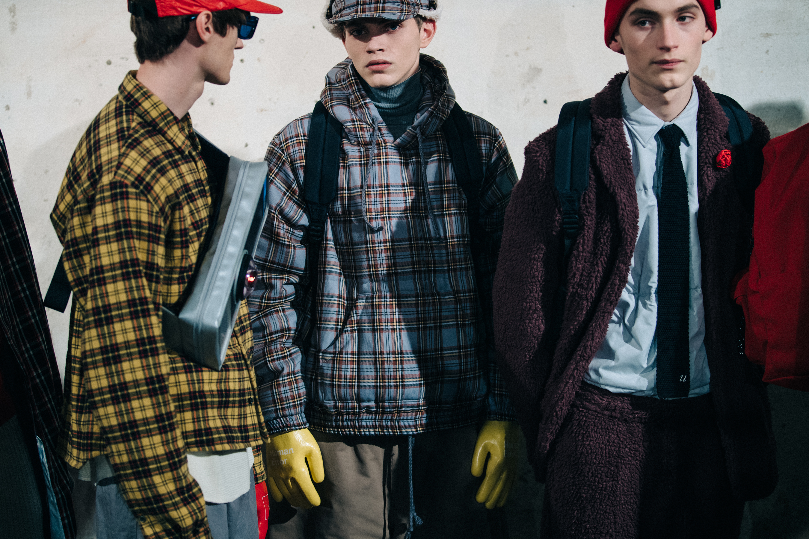 Three models wearing check outfits backstage