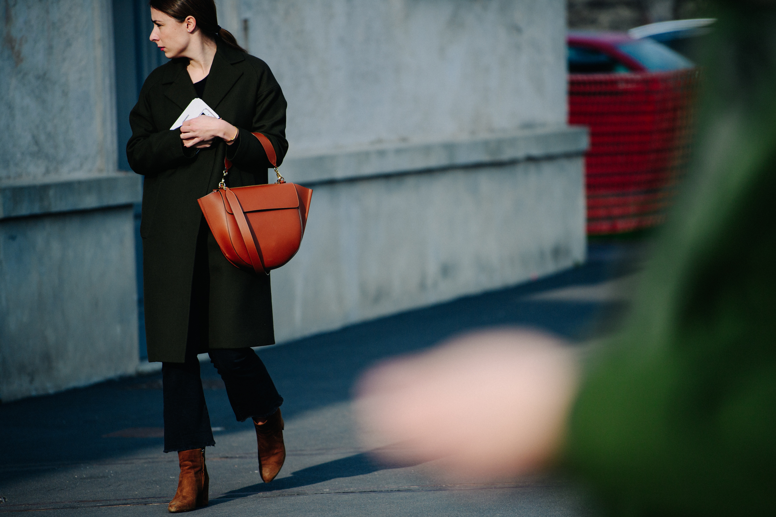 Woman holding brown leather bag