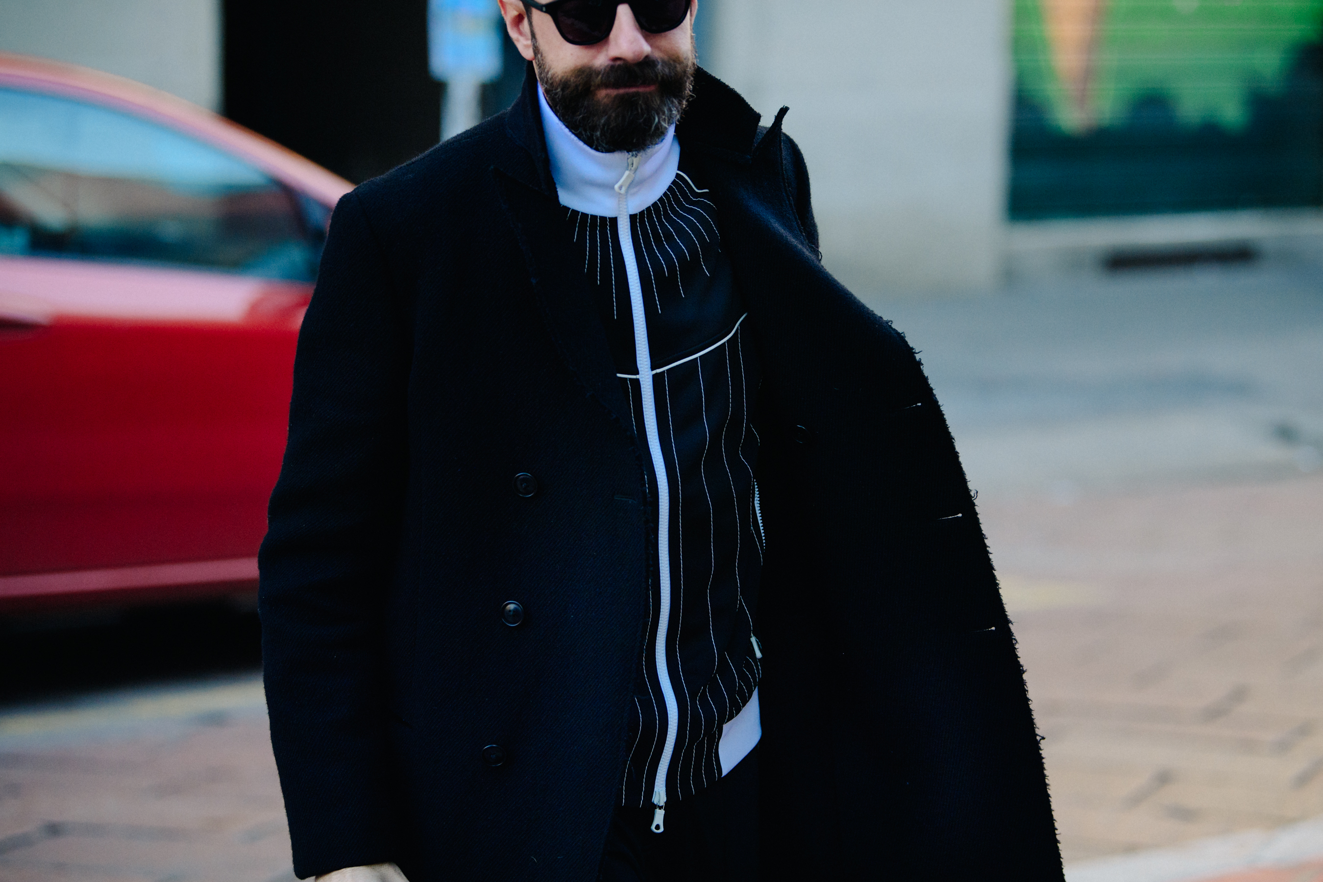 Man wearing navy and white track top