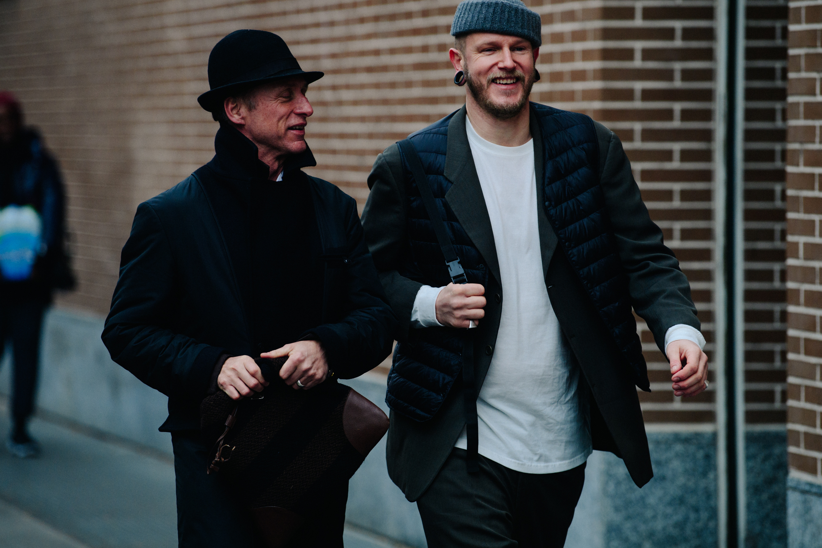 Two men wearing dark outfits