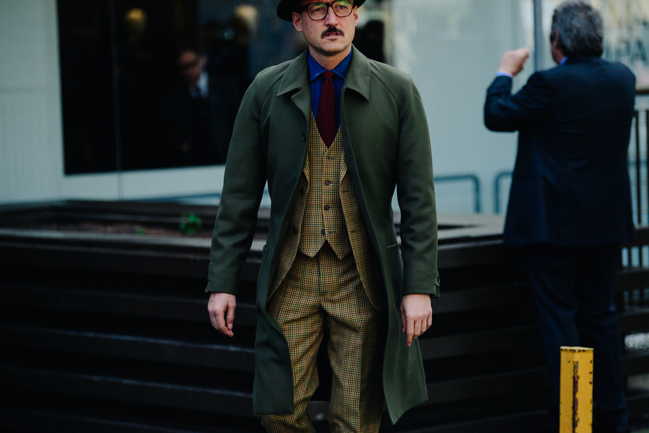 Man wearing green wool coat over suit
