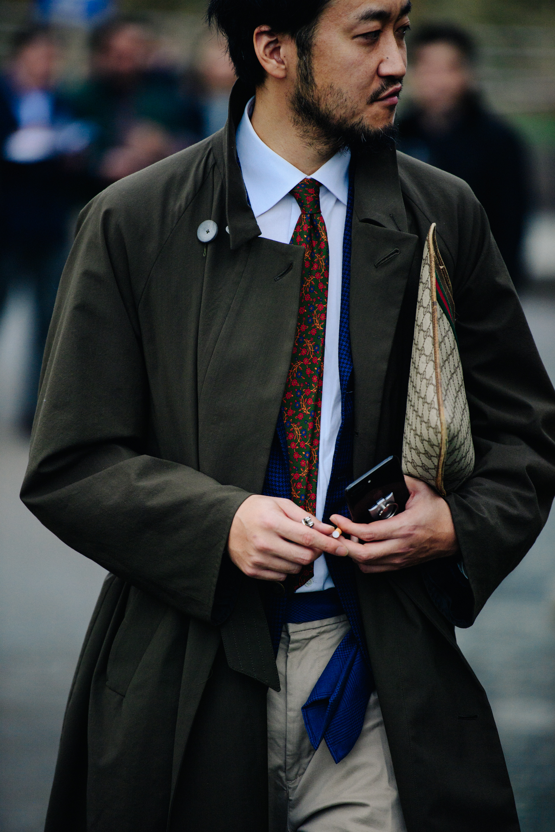 Asian man wearing long green coat
