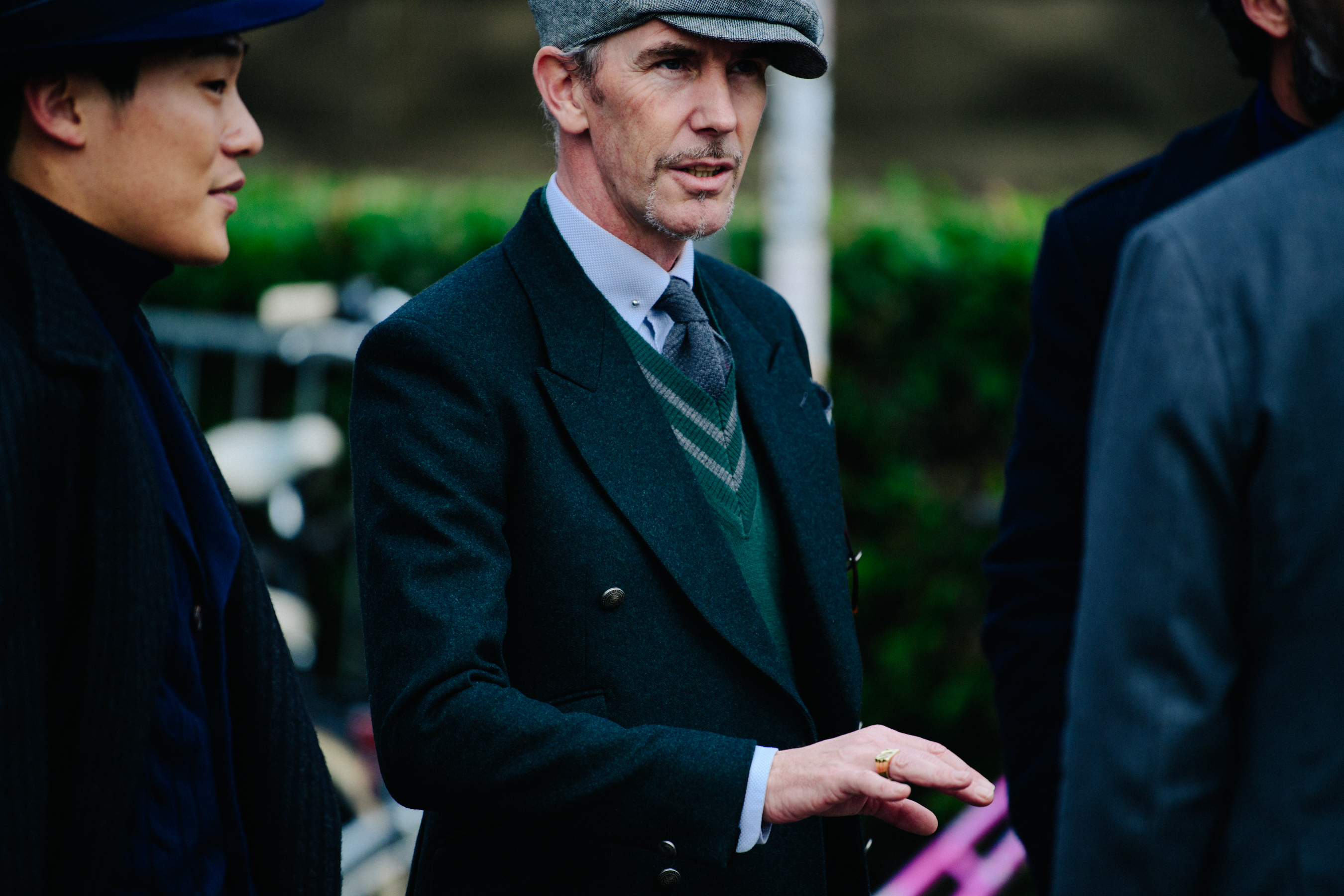 Man wearing smart grey and green outfit