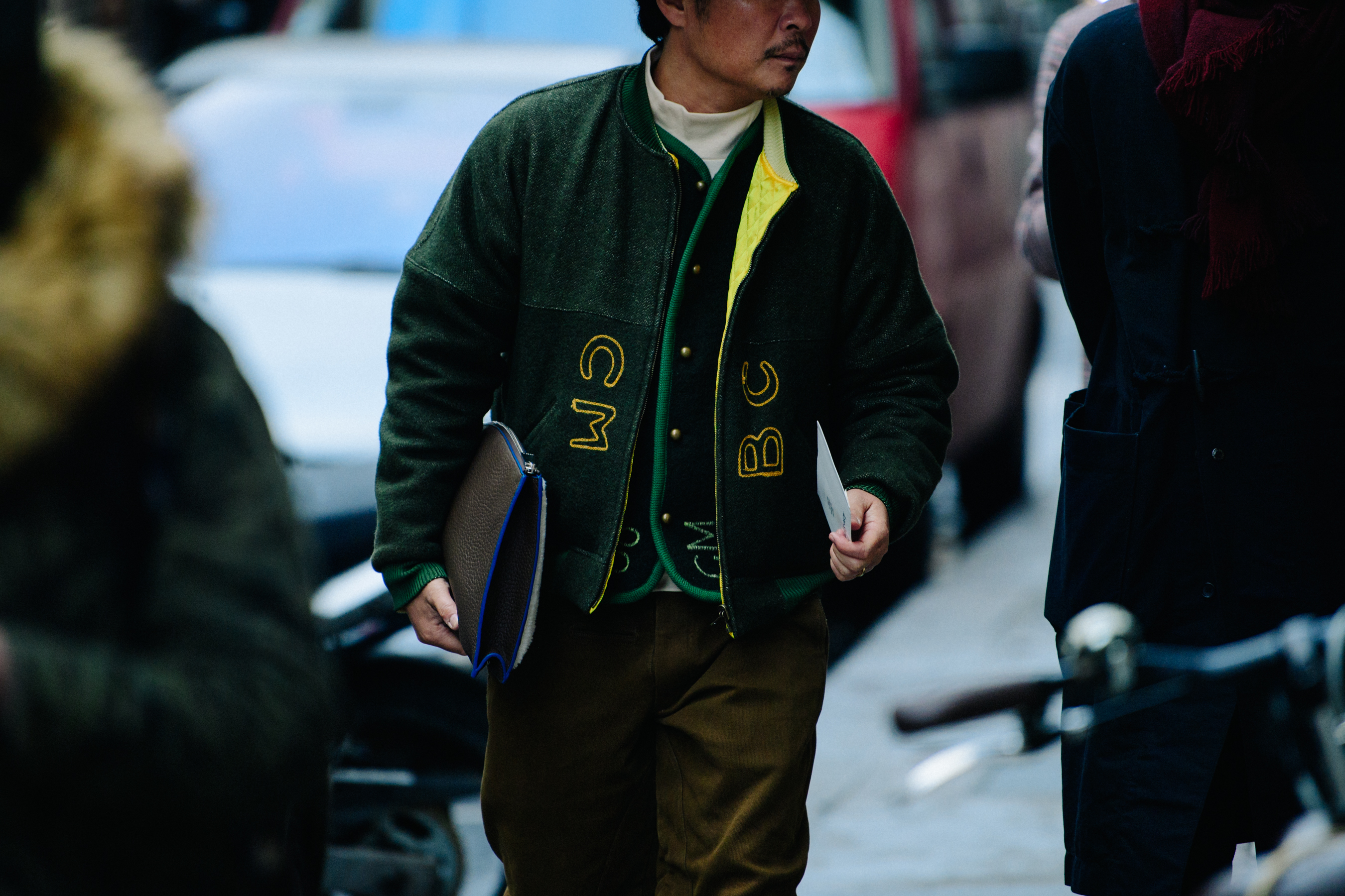 Asian man wearing green bomber jacket