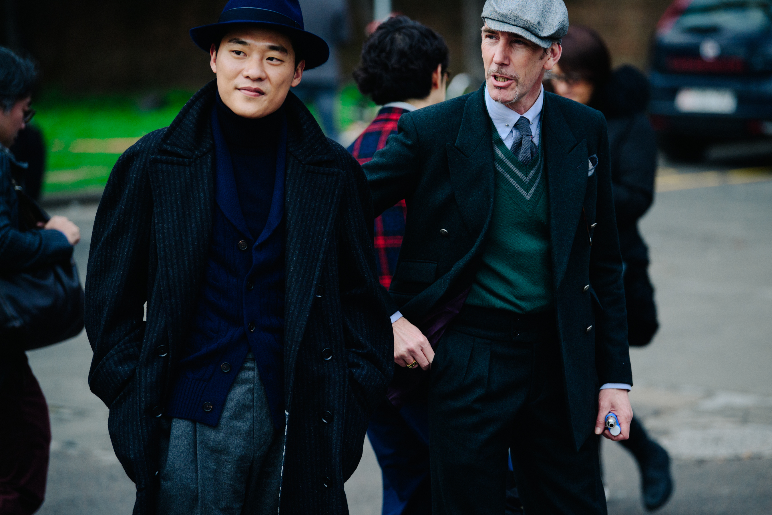 Two men wearing long overcoats