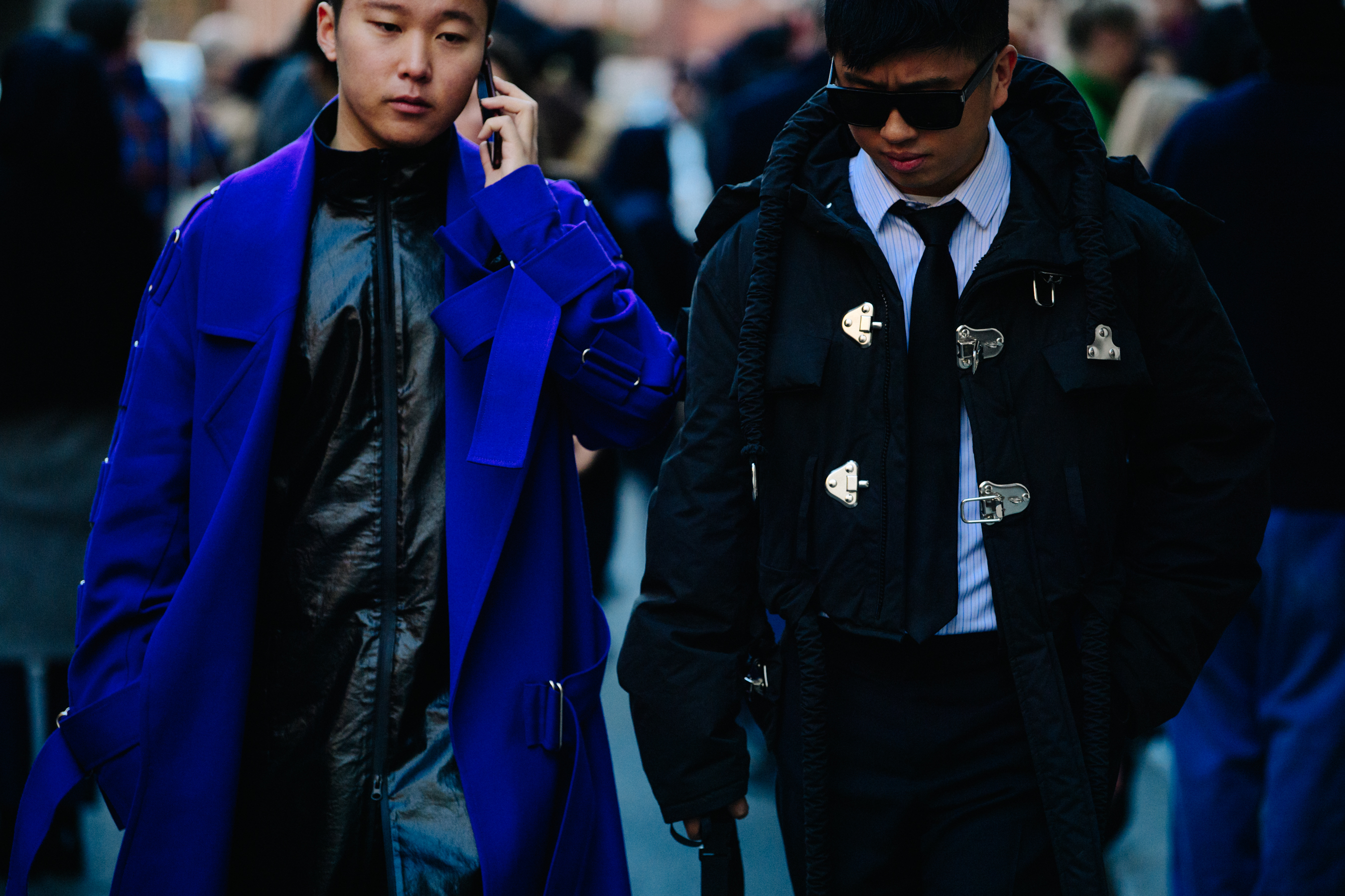 Two Asian men wearing black and blue coats