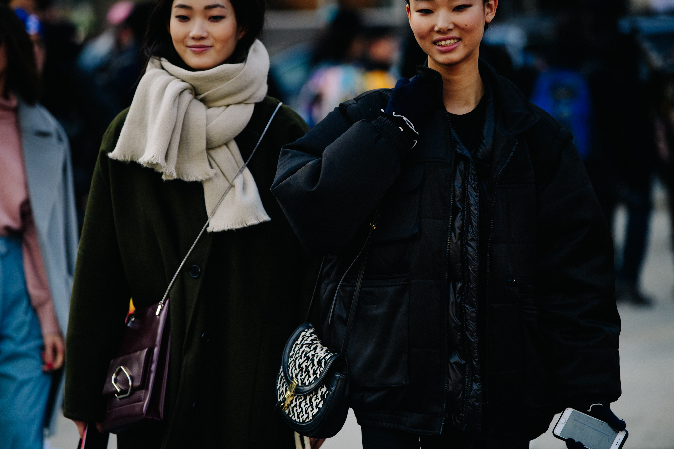 Two models wearing dark coats
