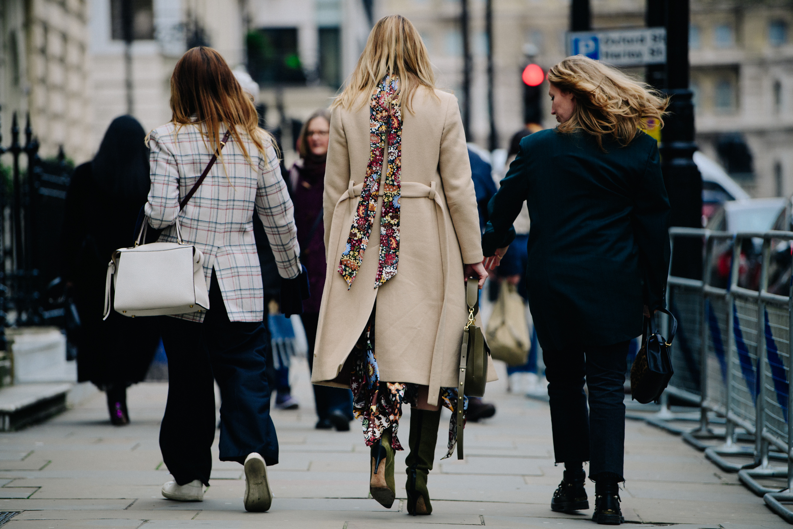 Three women carrying leather bags