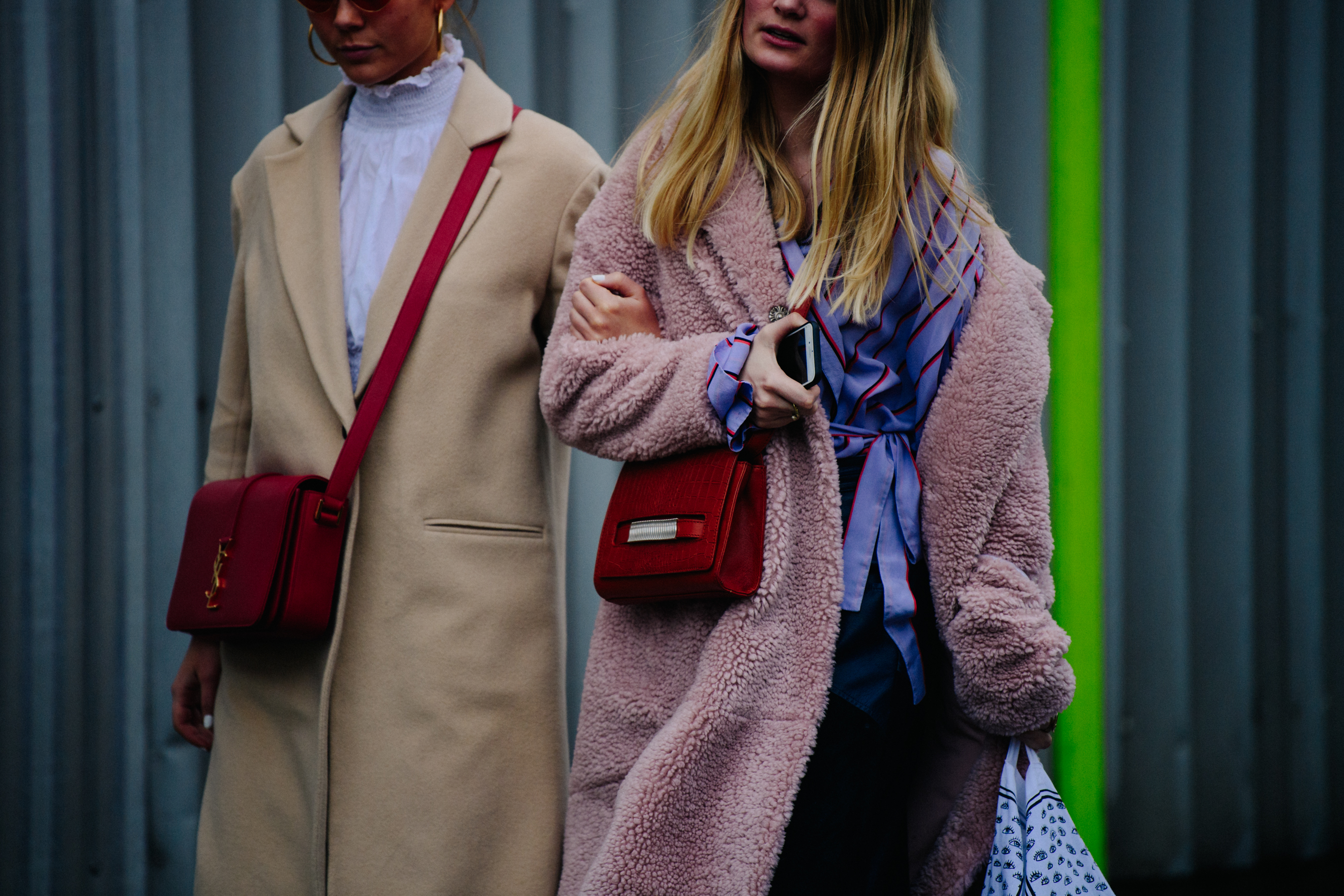 Two women wearing light coloured coats