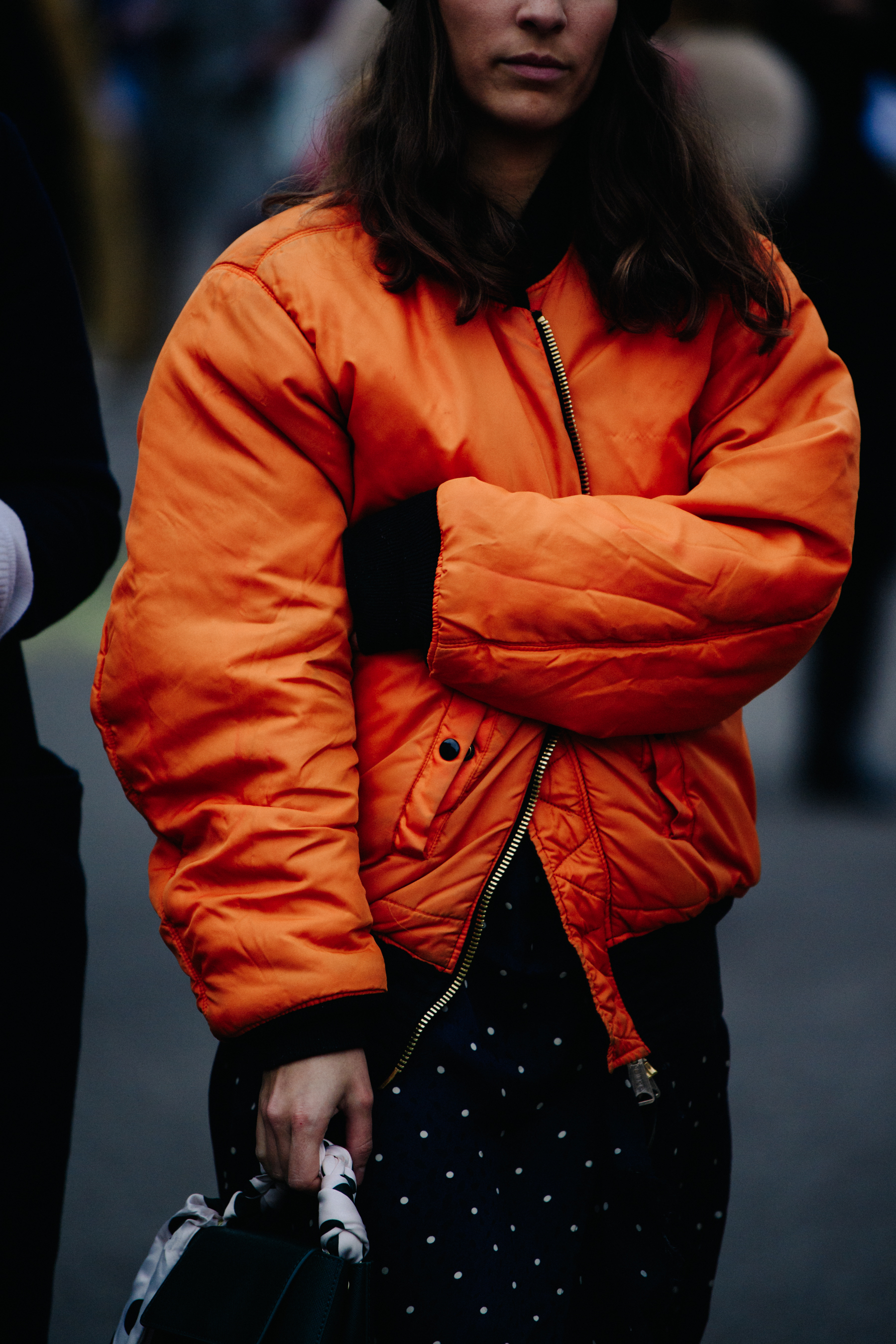 Woman wearing orange bomber jacket