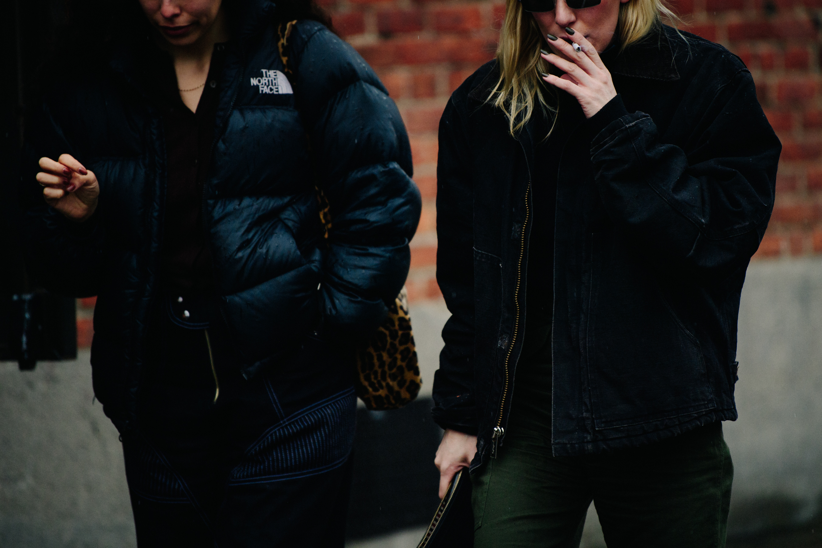Two women wearing short winter jackets