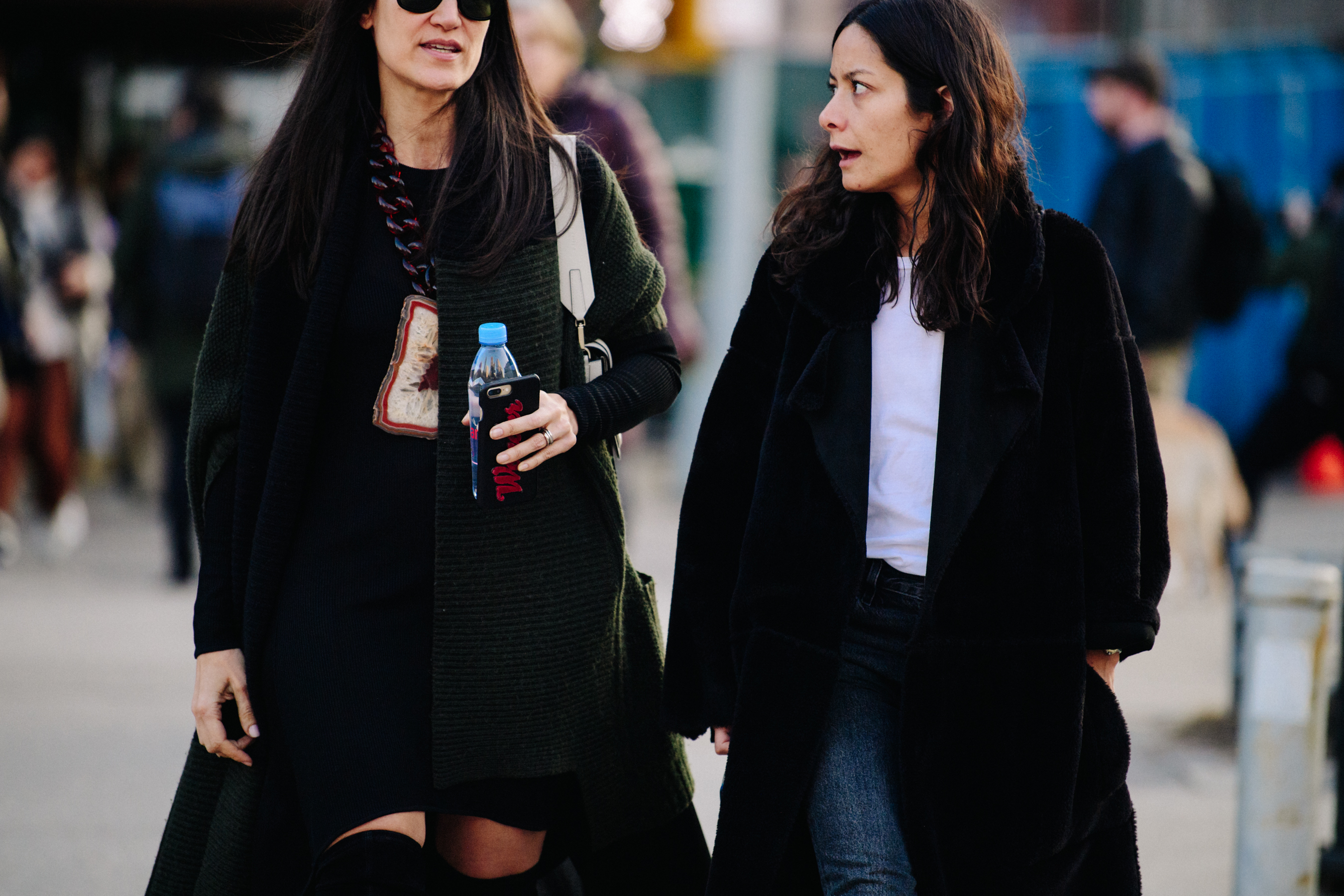 Two women wearing long coats